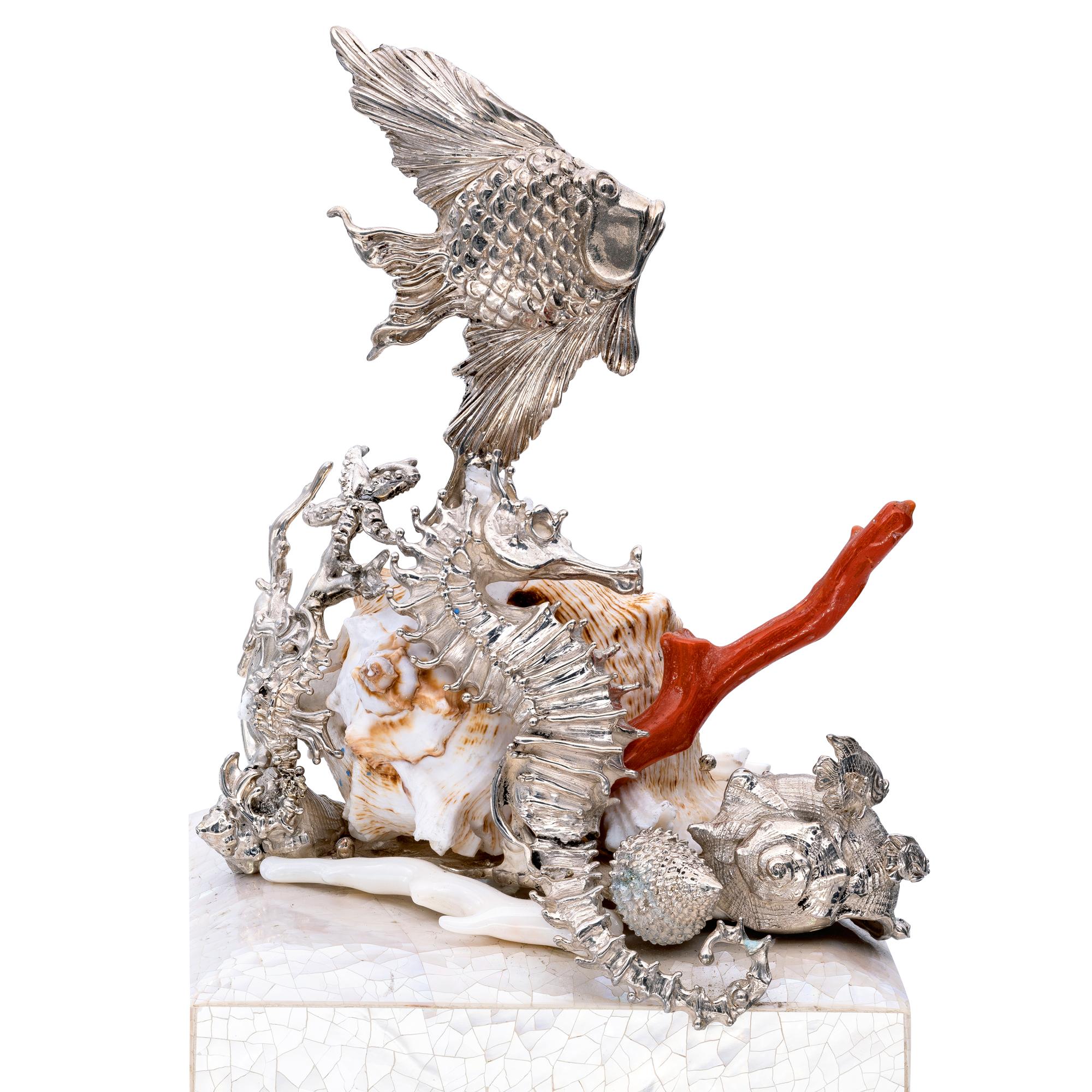 A Ocean Sculpture in full 925 ‰ Silver with Red Coral and Shells embrace the top of this Mother of Pearl Square Box
Fishes, a Seahorse, a fantasy of real and silver Shells bring a little piece of Precious Ocean in your home
The interior is in fine