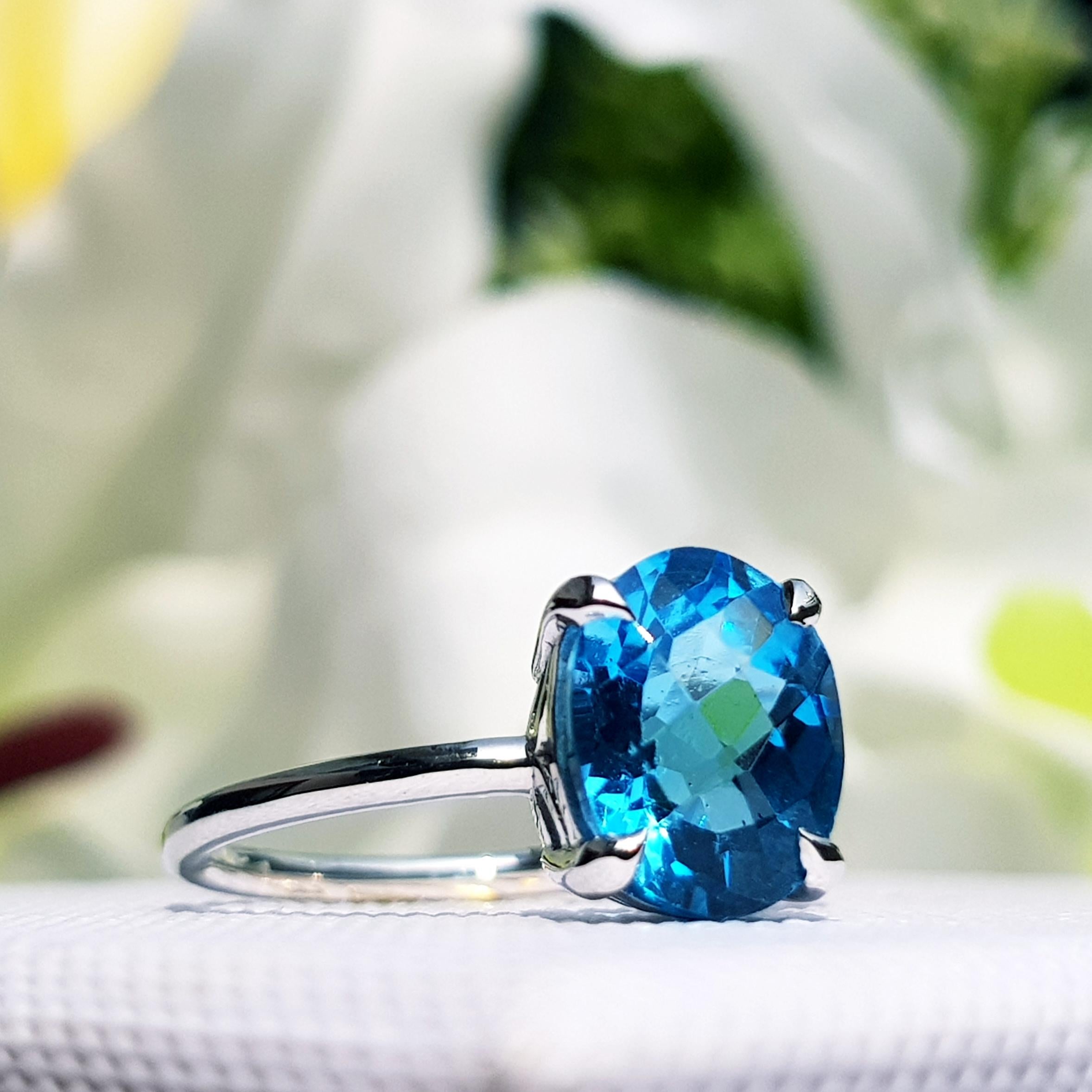 Deep blue sparkle and a modern 9k white gold setting make this Swiss blue topaz modern solitaire ring a striking pick. An oval 3.50 carats Swill blue topaz is the star of this piece and it’s held by four prongs. A simple and shining band crafted