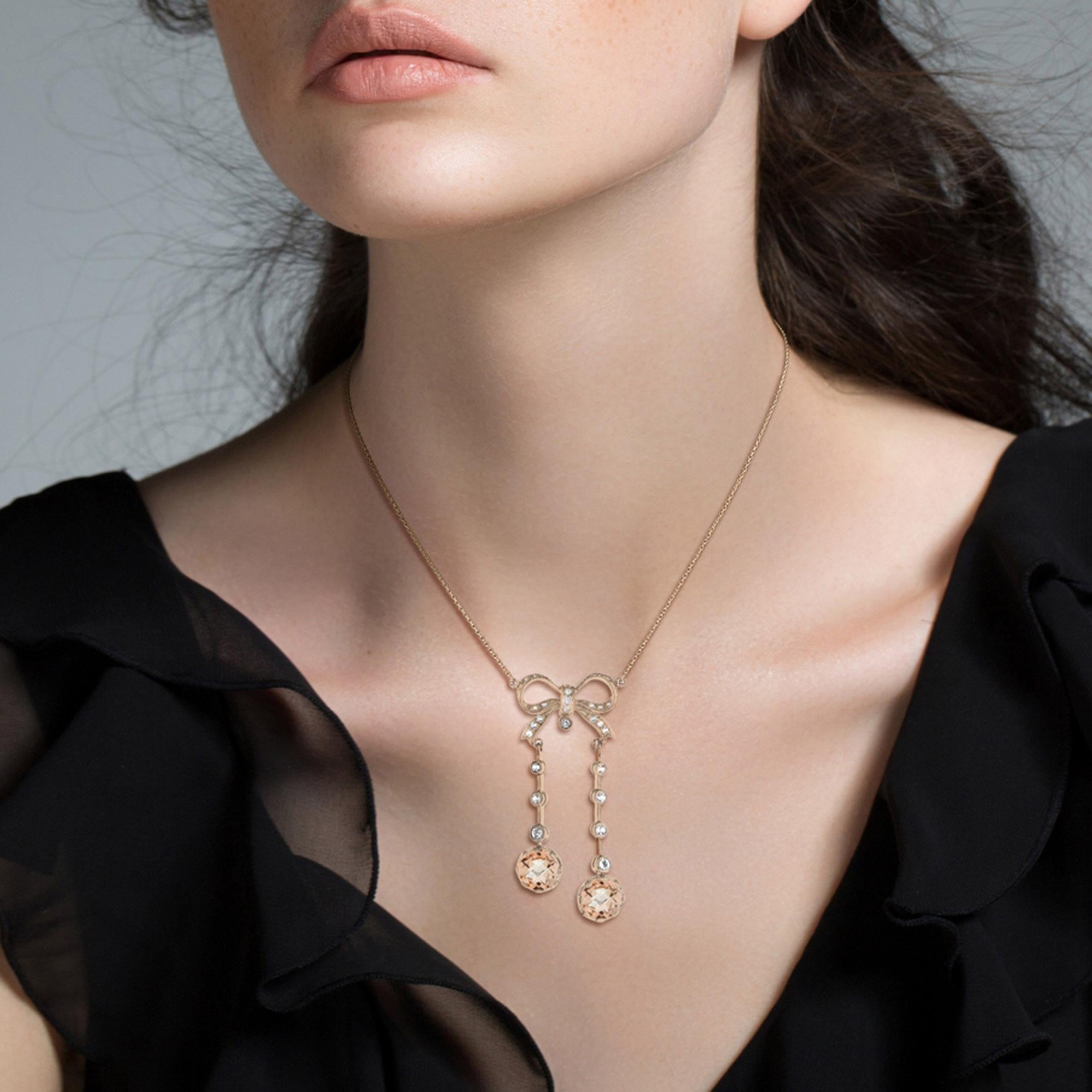 A 14k rose gold Edwardian style necklace comprised of two morganite and diamond drops, suspended below a bead-set diamond ribbon bow. The necklace is a wonderful example of Edwardian era jewelry and would make an ideal gift to the bride or someone