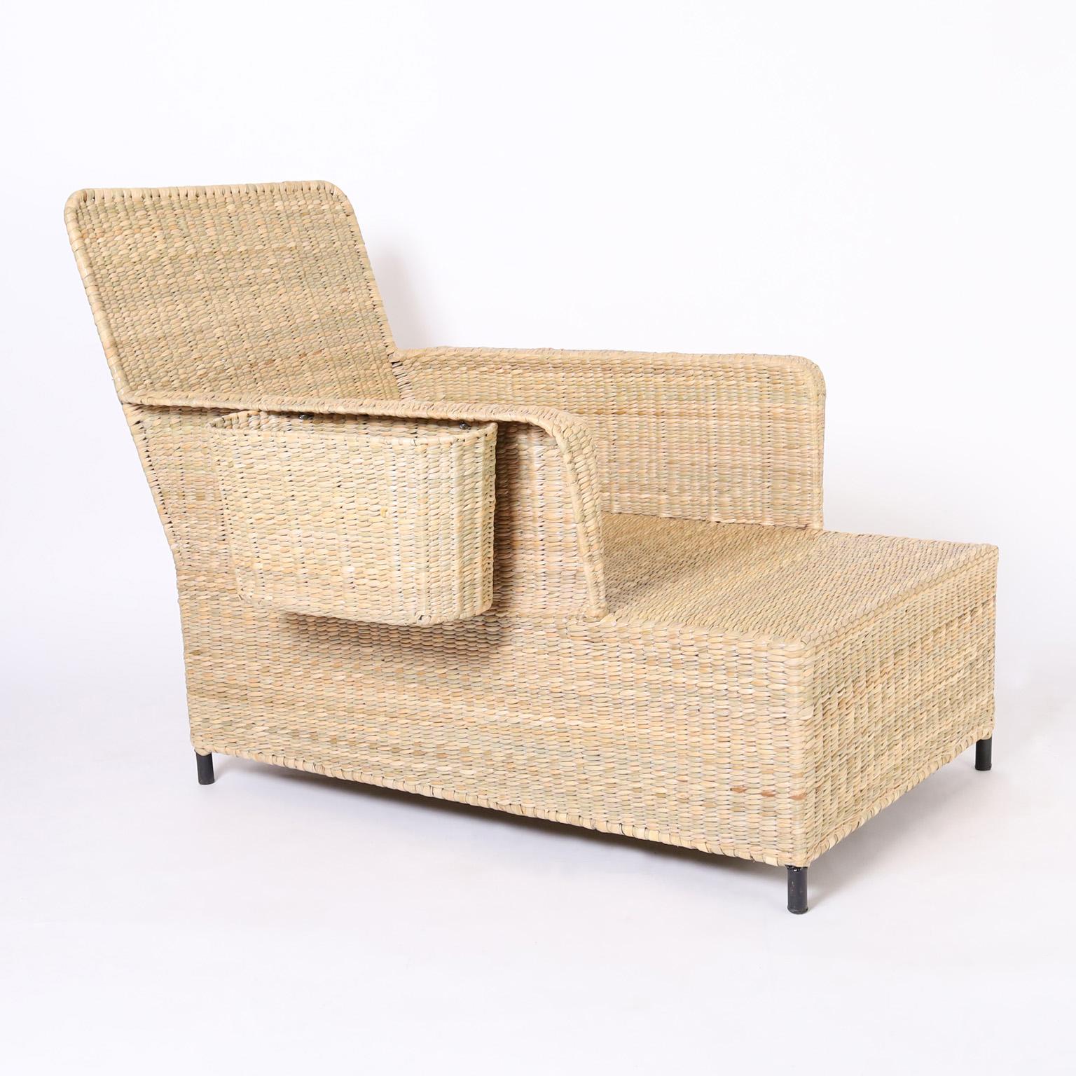 The Palm Beach, an impressive pair of midcentury inspired coastal chaise lounges with book or computer baskets handcrafted with durable metal frames ambitiously woven with reed in a chic form from the 2023 FS Flores Collection designed and