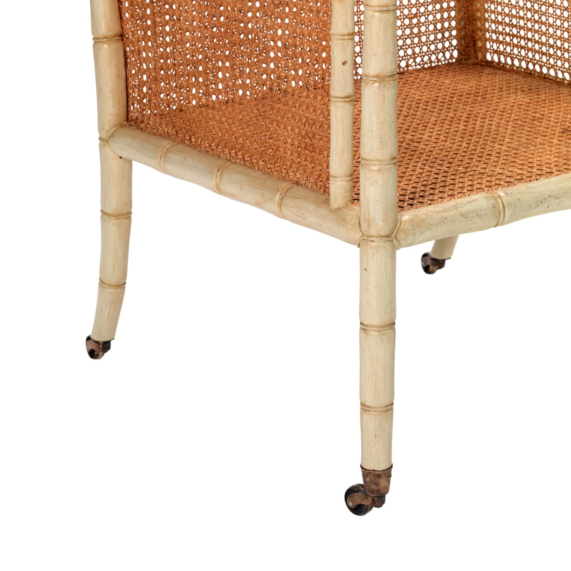 A faux bamboo and specialist aged painted caned Regency design library armchair. The chair with a loose fitted seat pad and rear loose cushion. To be upholstered in client’s own material.