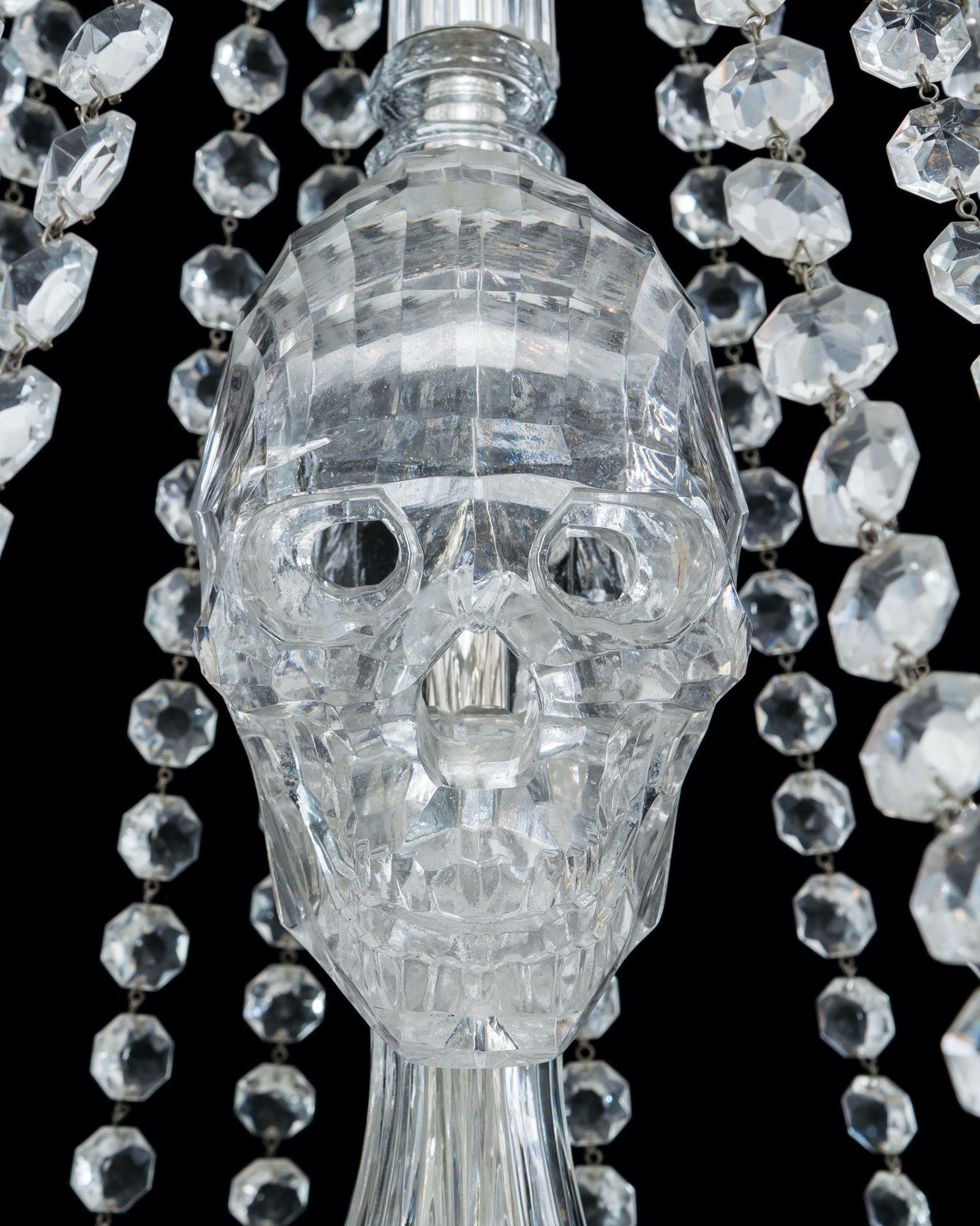 An extremely large, crystal chandelier of skeletal form. The chandelier consisting of thirty down hanging lights, each surrounded by a bell shade and mounted with crystal skeleton hand. The central shaft is formed by various cut stem pieces with a