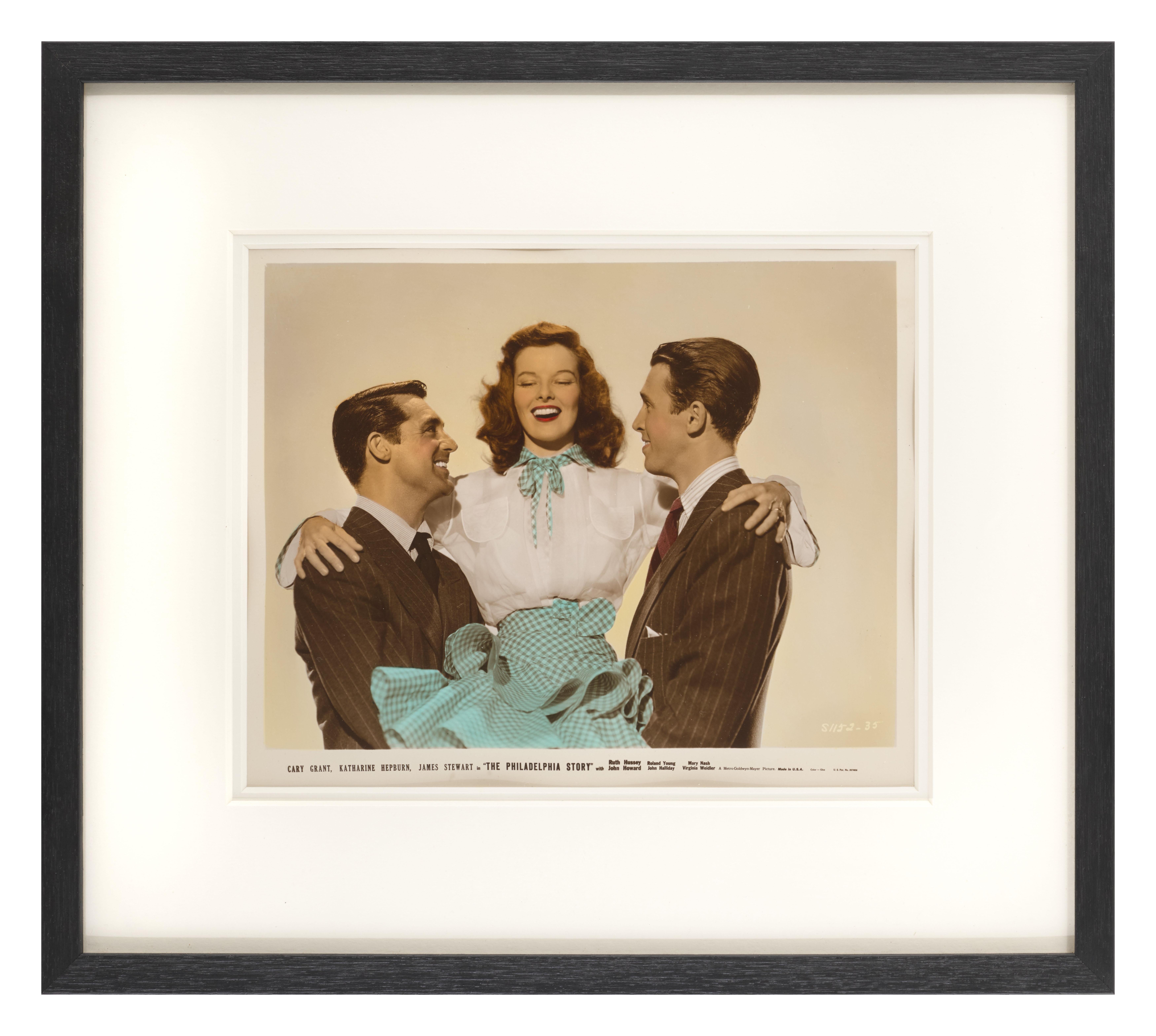 Originales farbiges Studio-Werbefoto für die klassische Komödie von 1940 
mit Cary Grant, Katherine Hepburn und James Stewart in den Hauptrollen.
Dieses Stück ist konservatorisch gerahmt und in einem  Rahmen aus Tulpenholz, säurefreie Passepartouts