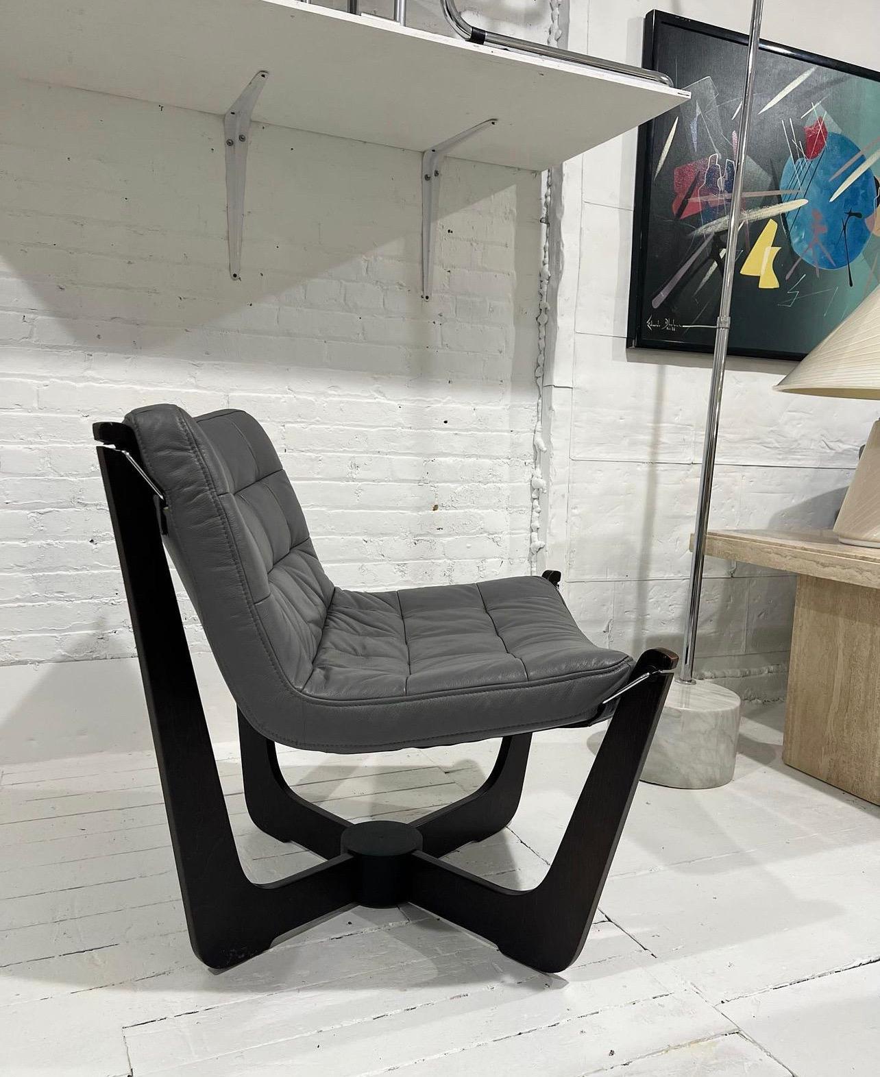 An incredibly comfortable, stylish & rare lounge chair! Genuine leather seat can easily be removed from the walnut frame and reattached when needed for transportation. The leather can also be removed for cleaning and reupholstery! Chair is in