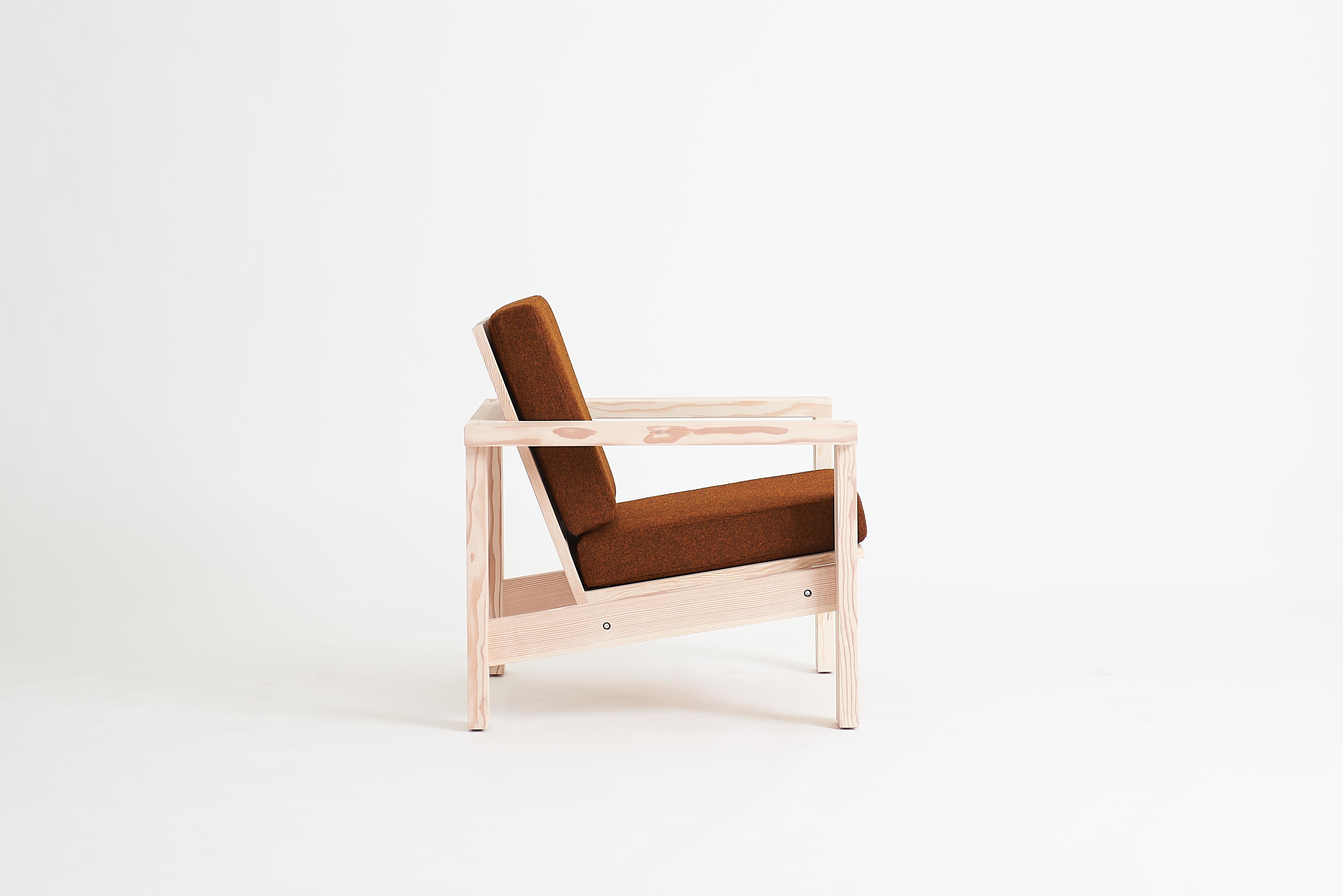 Der Plank Lounge ist ein Stuhl für den Innen- und Außenbereich, der auf der Verwendung allgemeiner Schnittholzgrößen basiert. Die abgewinkelten Sitz- und Rückenbretter werden von einem sichtbaren Rahmen getragen. Die gepolsterten Kissen liegen