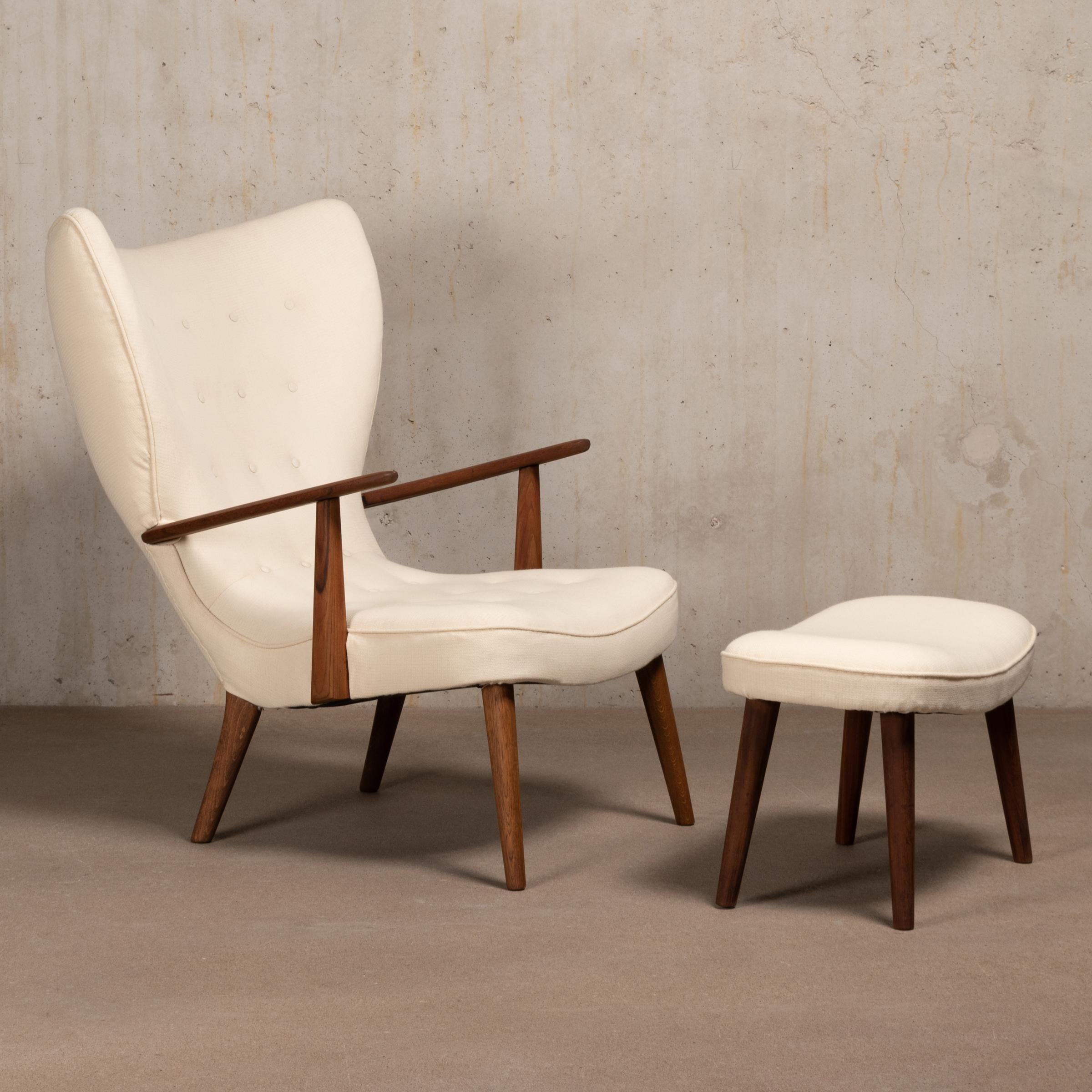 Famous sculptural and sensuous wingback / lounge 'Pragh' chair designed by Madsen & Schubell. Stained oak / beech and teak frame with light beige fabric. The upholstery is in good condition with light staining, though the chair would benefit with a