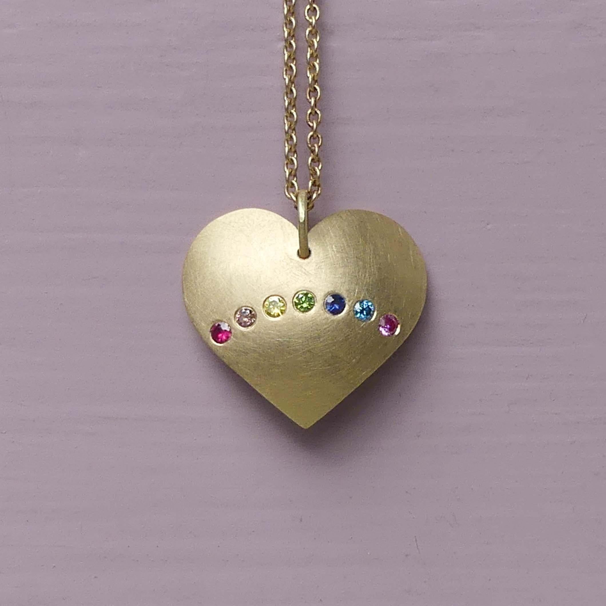 The Rainbow Heart Warrior Amulet is a domed gold 18ct Fairmined gold heart and five coloured diamonds, a ruby and a blue sapphire.

The Rainbow Heart is a happy playful charm,  created in order for us to remember the infinite joy we have access to