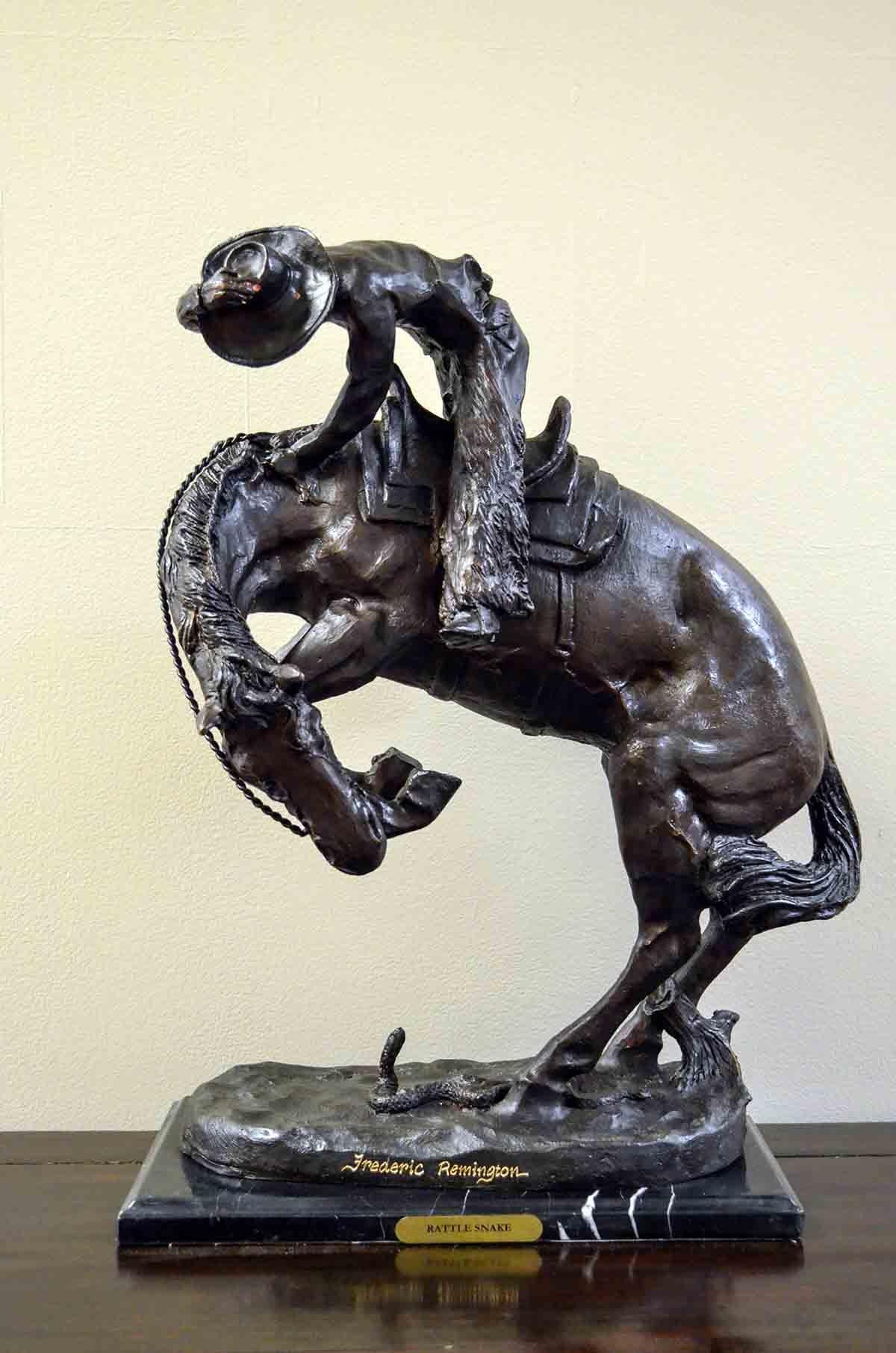The Rattlesnake, a cast bronze sculpture after American artist Frederic Remington on marble base. Filled with a tremendous dramatic tension, this bronze sculpture depicts a scene from the American Old West particularly dear to Frederic Remington. A