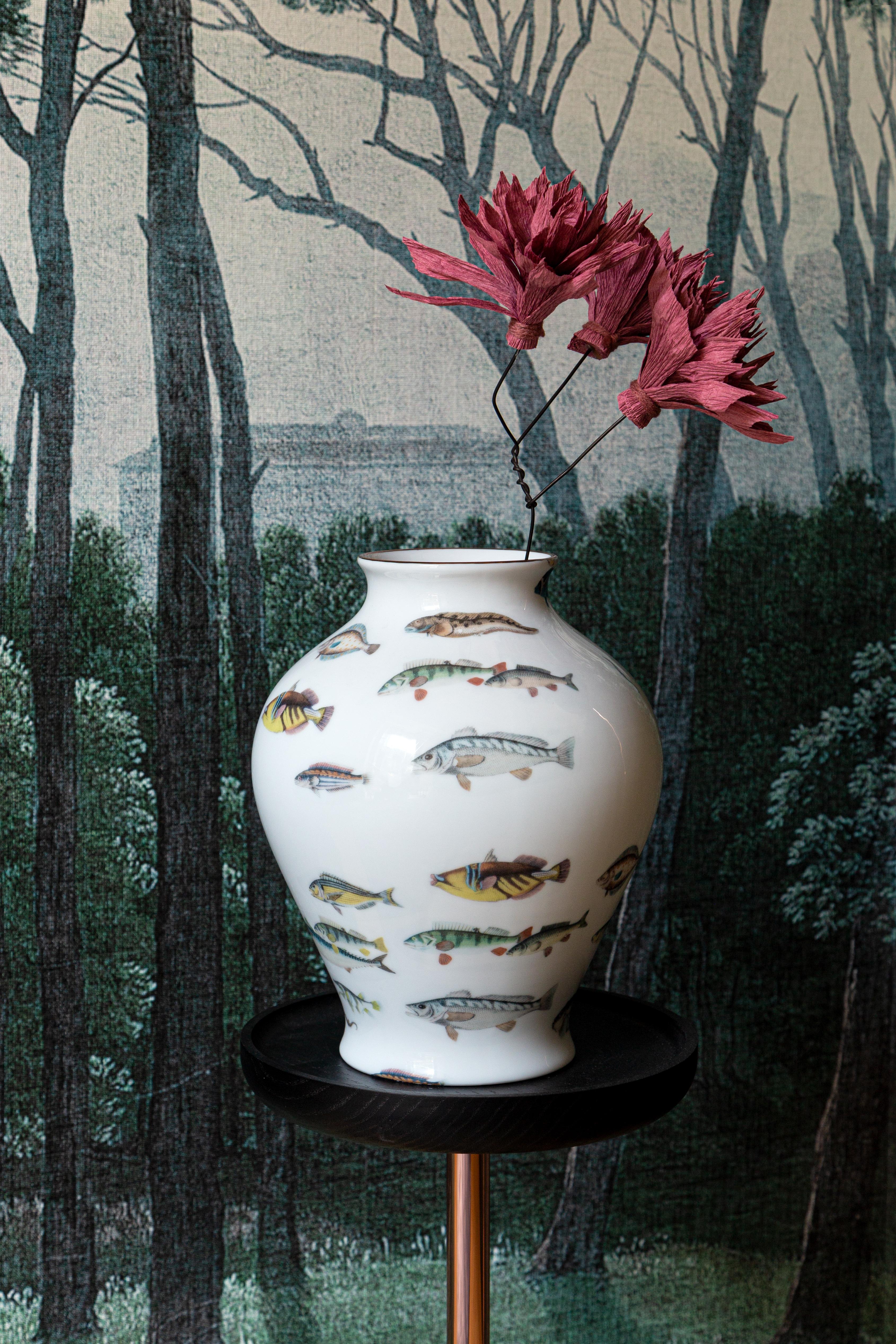 Le design classique de ce vase en porcelaine reprend vie avec des décorations rétro à la saveur contemporaine. Un banc de poissons tropicaux tourbillonne à la surface du vase.