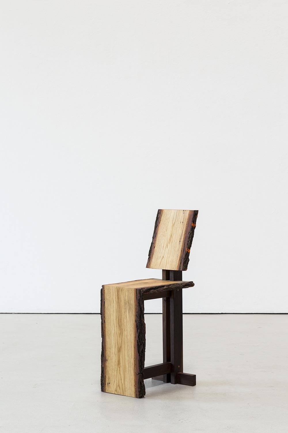 This unique chair is constructed from natural oak boards that retain their original bark, combined with smoked oak elements for added contrast and character. The joints are reinforced using pine dowels and glued for stability, ensuring both strength