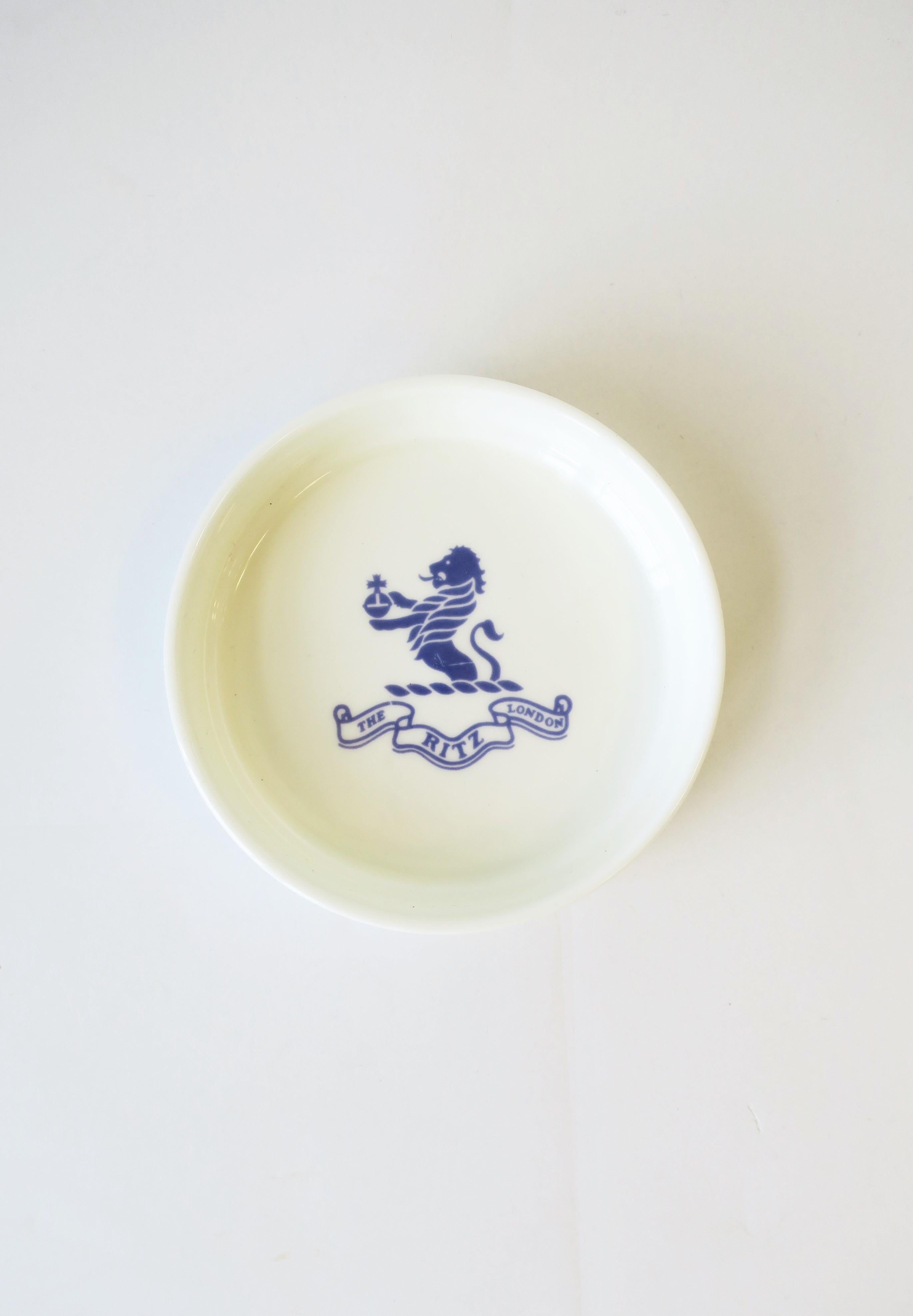 From 'The Ritz London' a round blue and white porcelain jewelry dish with Lion crest detail. A great catchall for jewelry or other small items for desk, vanity, nightstand area, etc. Piece is fine bone-china porcelain made by Royal Doulton, England,