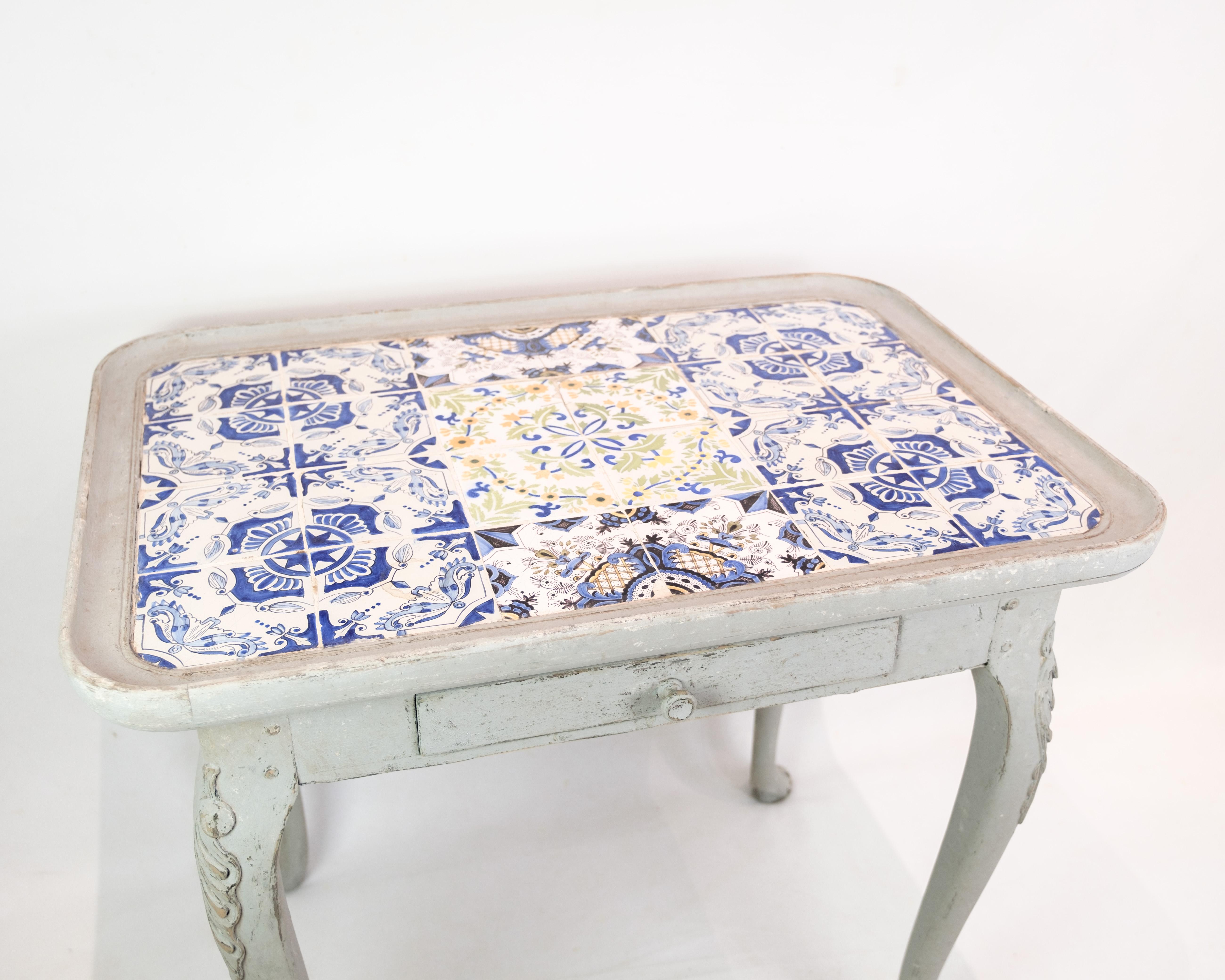 The rococo tile table, painted gray and dated 1780, is a charming example of classic furniture design. Its elegantly curved forms and refined detailing are characteristic of the period and add a historical charm to any room. This timeless piece of
