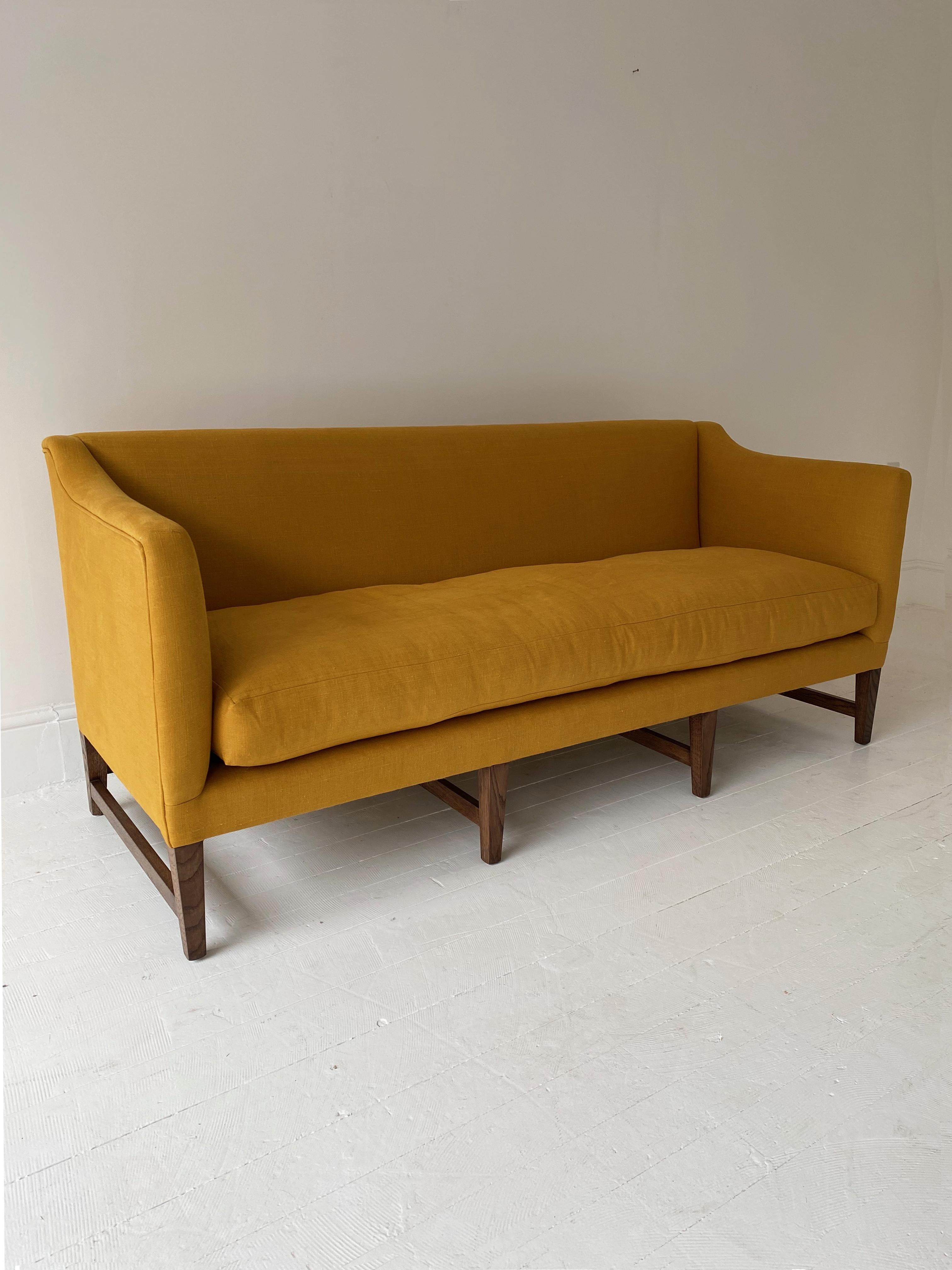 Being offered here is the newly made Ross Regency sofa by Noble. Built and upholstered for promotional and photography purposes. Covered in a beautiful dyed yellow Scottish linen with a plump feather and down cushion. 

The sofa is a faithful and