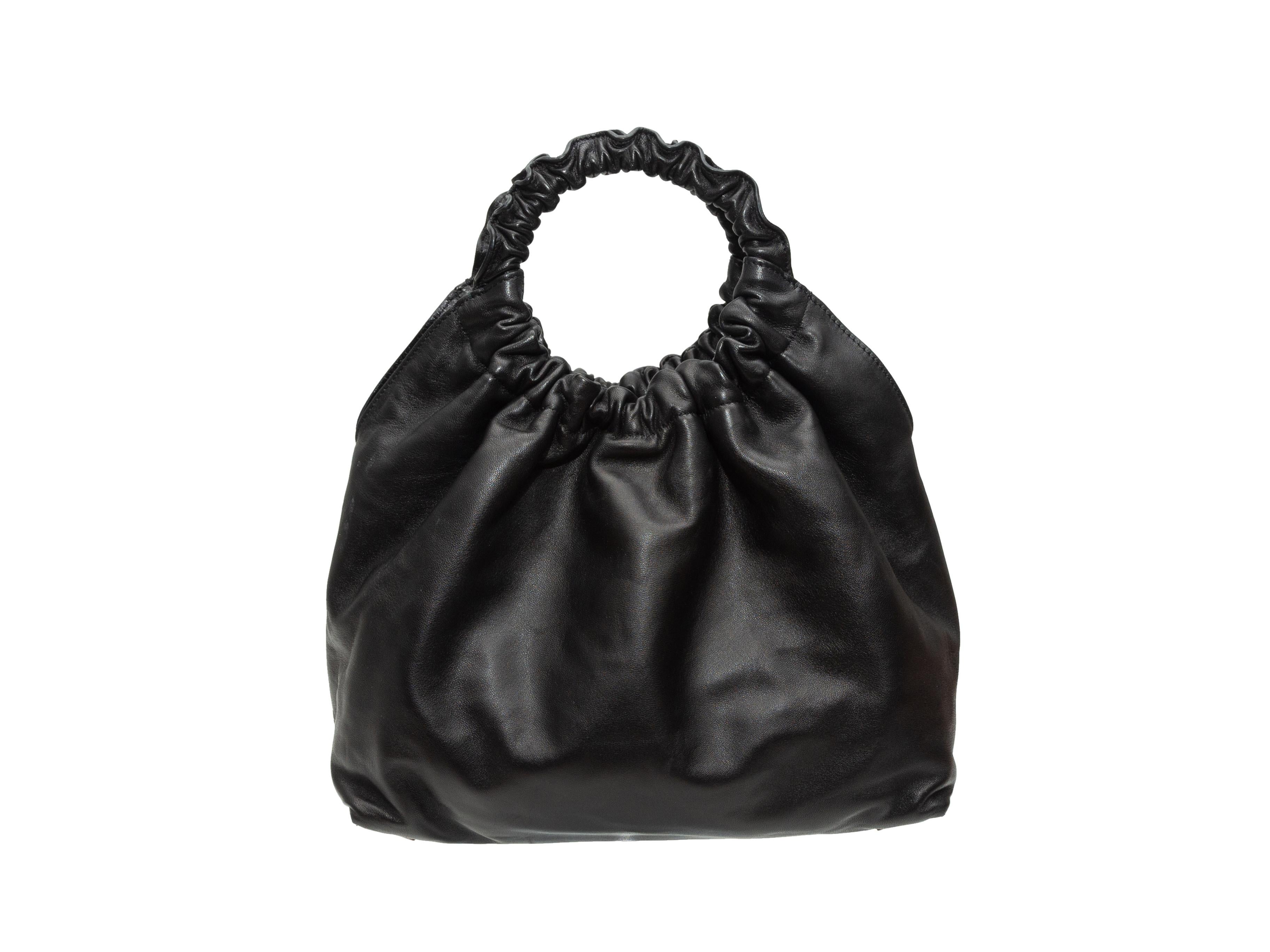 Product details: Black leather small Double Circle bag by The Row. Interior zip pocket. Dual top handles. Optional crossbody strap. Magnetic closure at top. 13