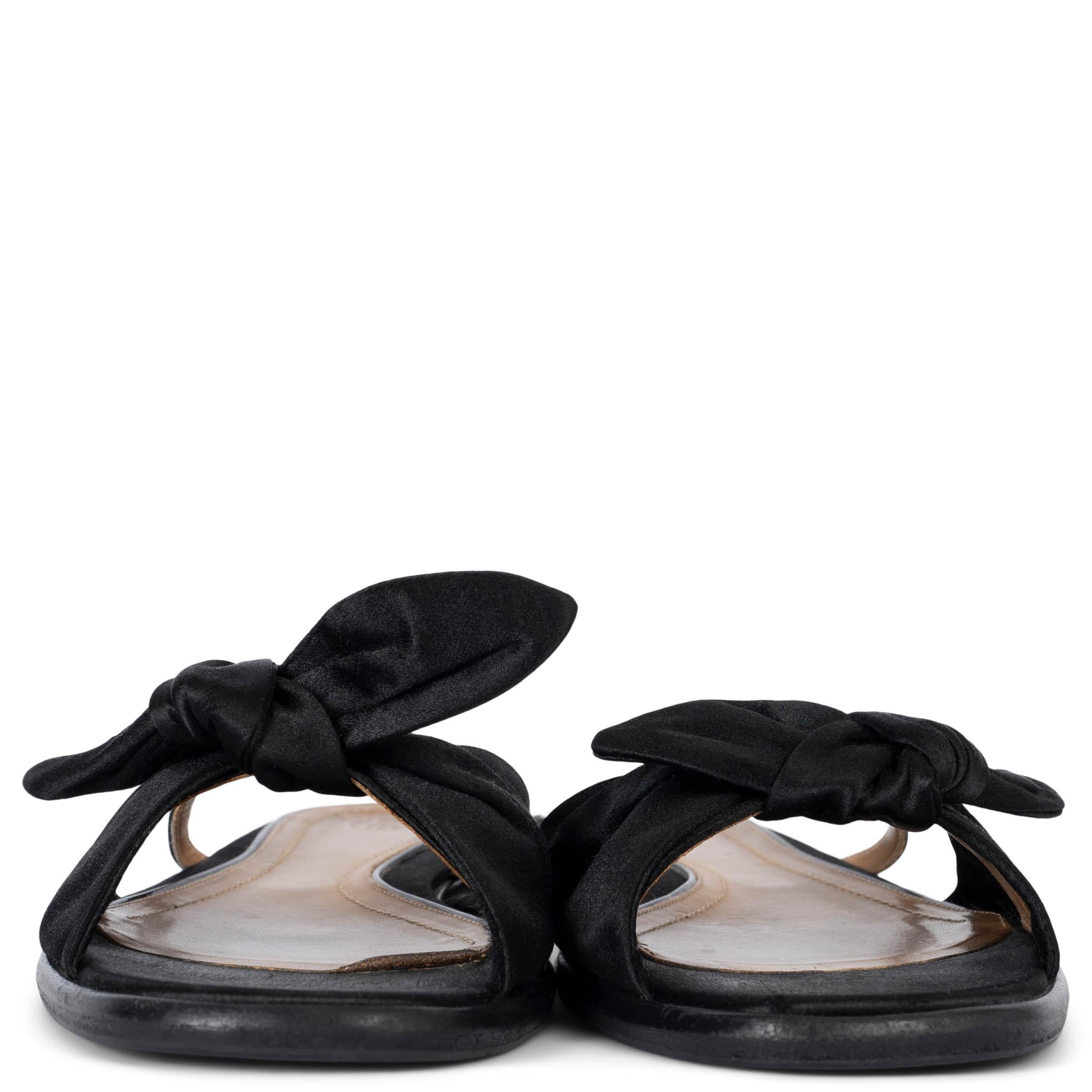 100% authentic The Row April slide sandals in black satin silk (100%). Feature leather trim at the sole and are embellished with a bow. Have been worn and shows some wear and discoloration to the sole. Rubber sole has been added. Overall in very