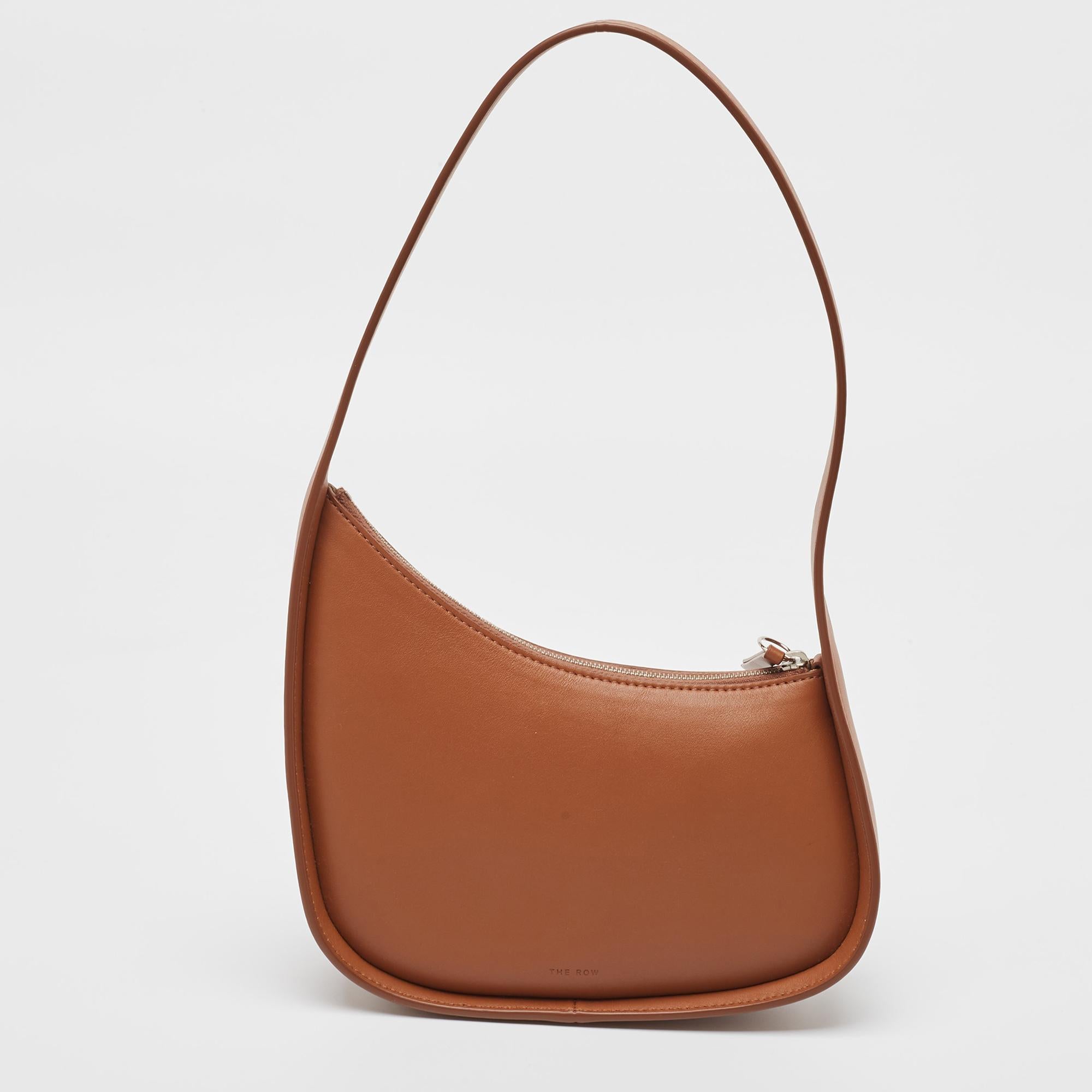 Experience fine craftsmanship with this immaculately designed leather bag by The Row. It has a half-moon shape with a single handle and a suede interior.

Includes: Original Dustbag