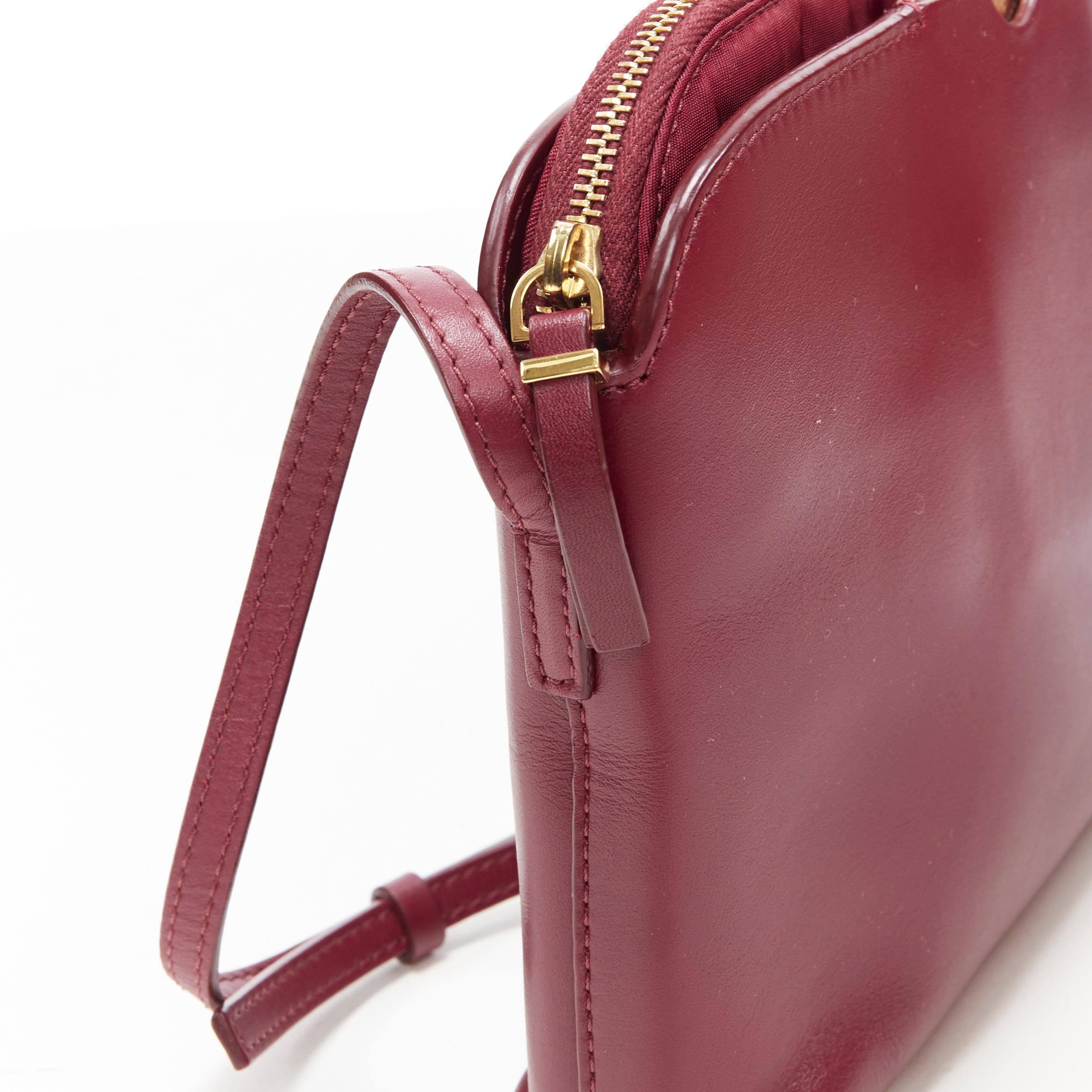 THE ROW bolso bandolera con tres bolsillos y cremallera de inspiración vintage en rojo burdeos y espejo dorado 2
