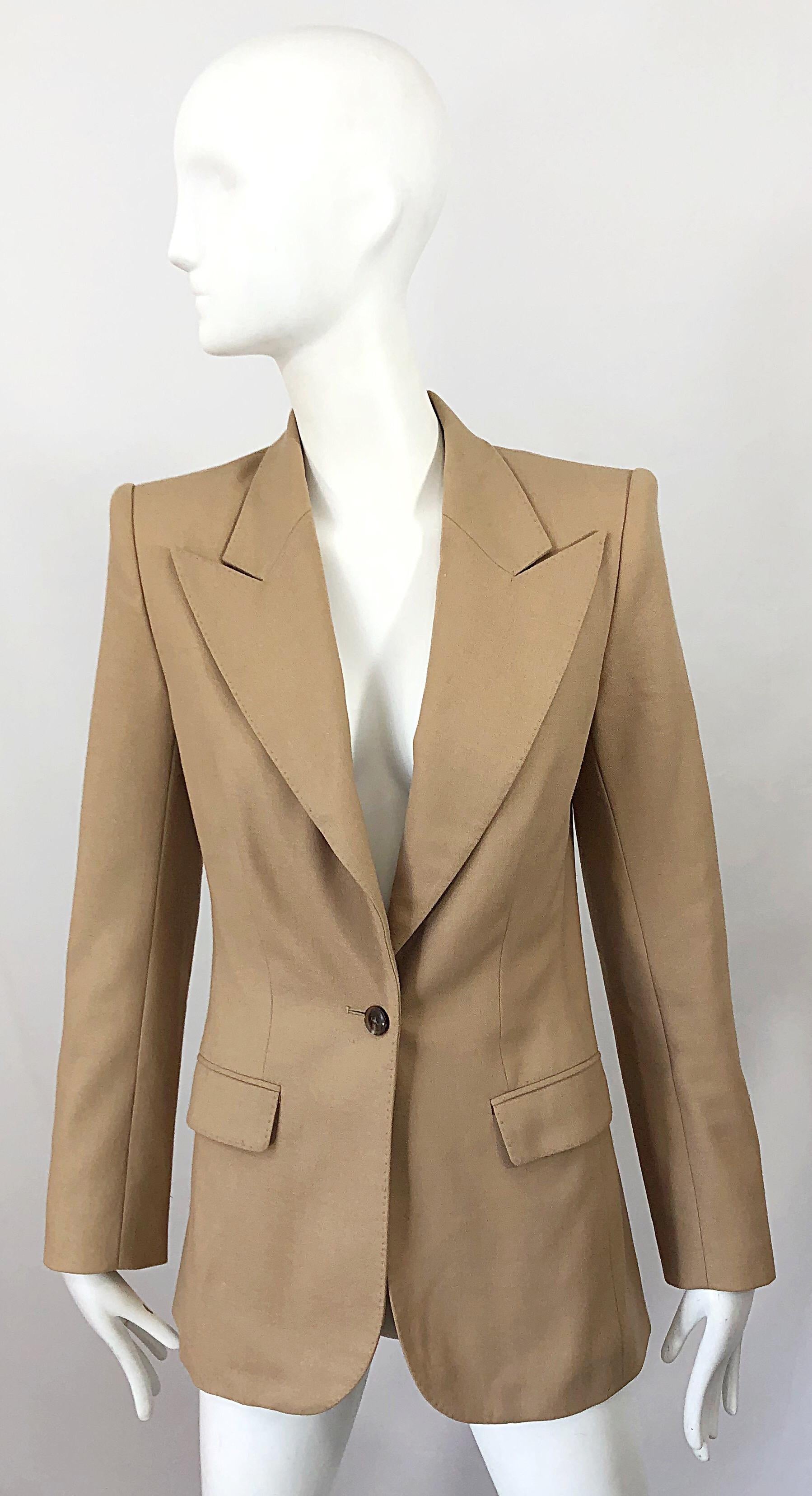 Sleek camel wool blazer by THE ROW! Features soft virgin wool that is fully lined in a soft pink silk (even the pockets are lined). Single button closure, with YSL style exaggerated lapels. Pockets at each side of the waist, Can easily be dressed up