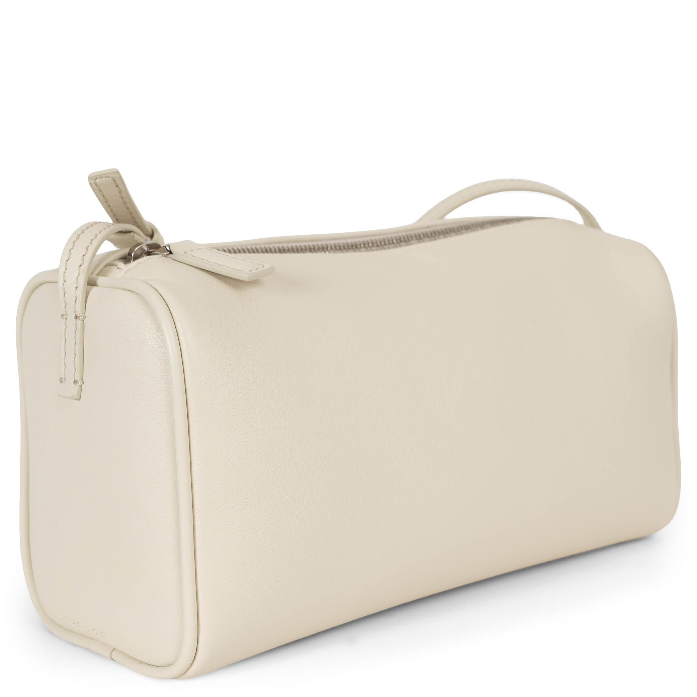 This 100% authentic The Row 90's bag in ivory grained leather embodies understated sophistication. Designed with a slim, adjustable top handle and softly rounded edges with piping, it exudes a refined minimalist aesthetic. Signature embossing on the
