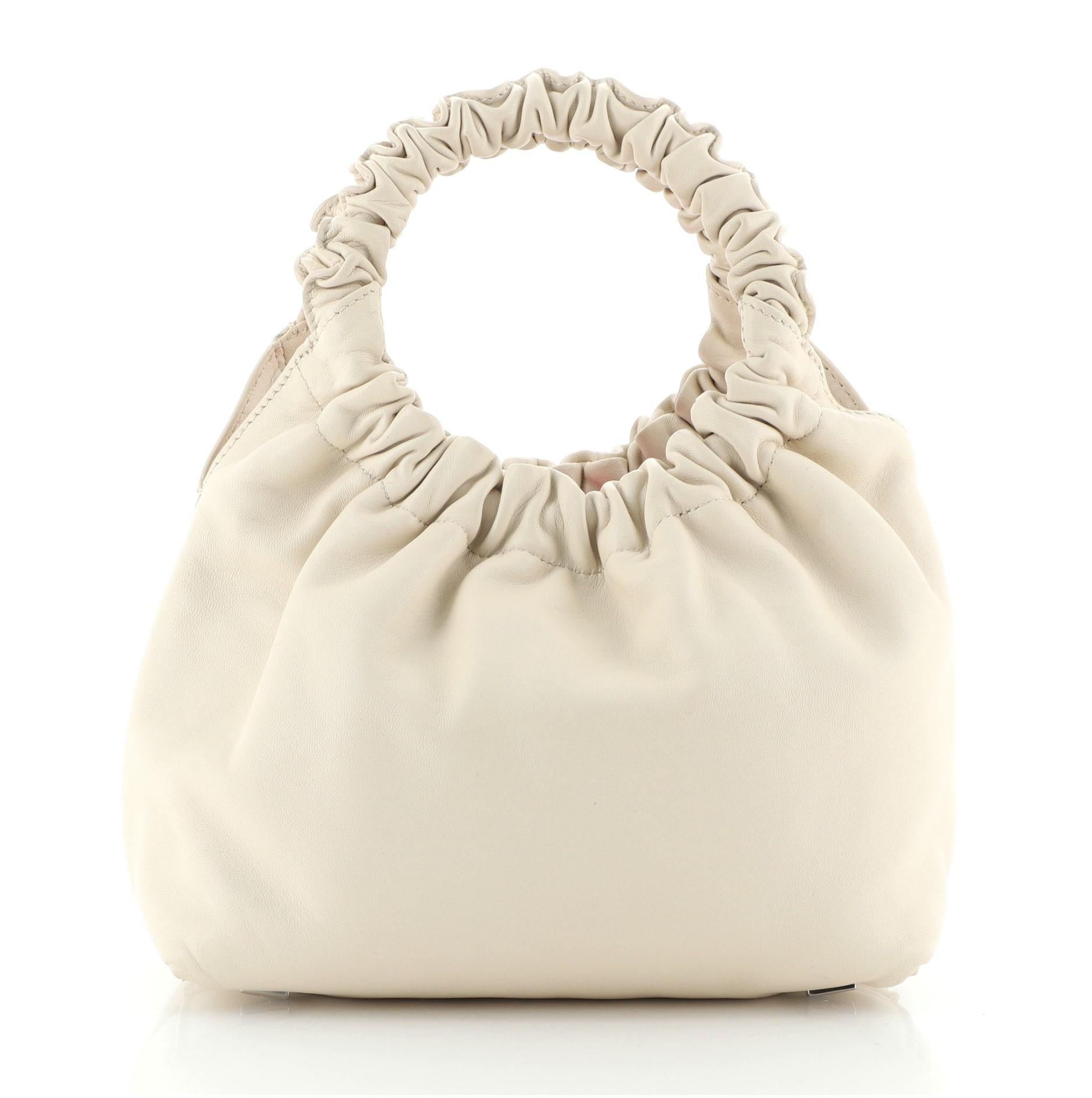 The Row - Sac double cercle en cuir, petit
Neutre

Détails de l'état : Usure mineure sur les coins de la base, les bords de l'ouverture et les poignées, léger froissement à l'extérieur. Fente sur les bords de la cire de l'ouverture latérale, rayures
