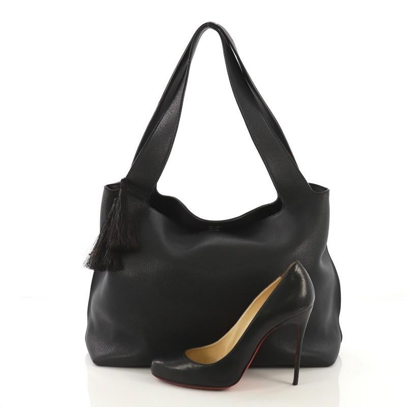 This The Row Duplex Hobo Leather, crafted in black leather, this bag features dual flat leather straps and gold-tone hardware. Its zip and magnetic closures open to a black suede and beige fabric interior with two open compartments and middle zip