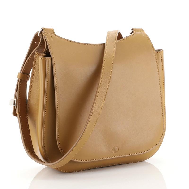 This The Row Hunting Crossbody Bag Leather 9, crafted in brown leather, features an adjustable leather strap, back slip pocket and silver-tone hardware. Its flap with magnetic snap closure opens to a neutral suede interior with zip and slip