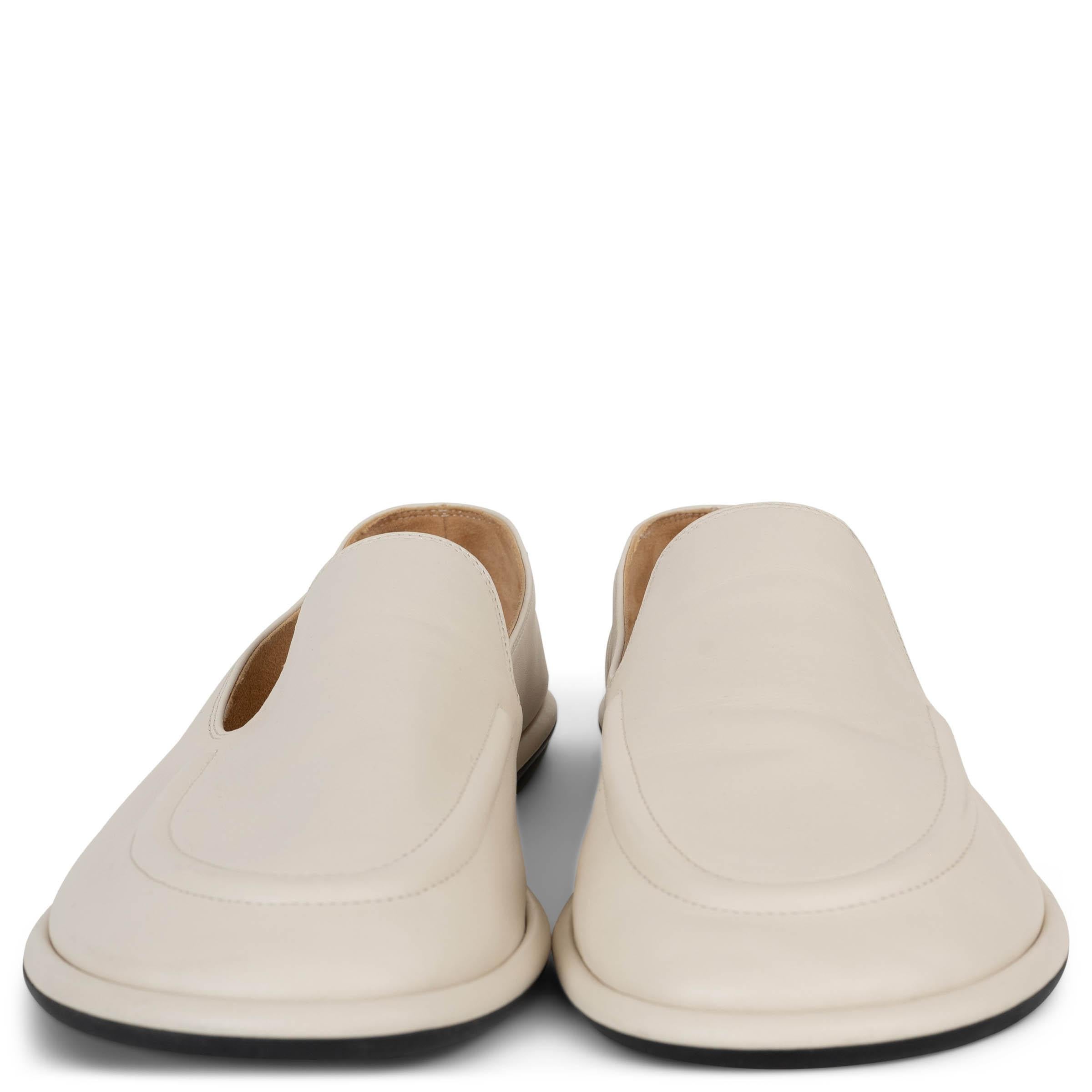 This 100% authentic The Row Canal loafers in Milk white leather offer a modern twist on classic minimalism. Designed with off-kilter rounded toes, they are lined in soft beige suede for exceptional comfort. Finished with rubber soles and a slip-on