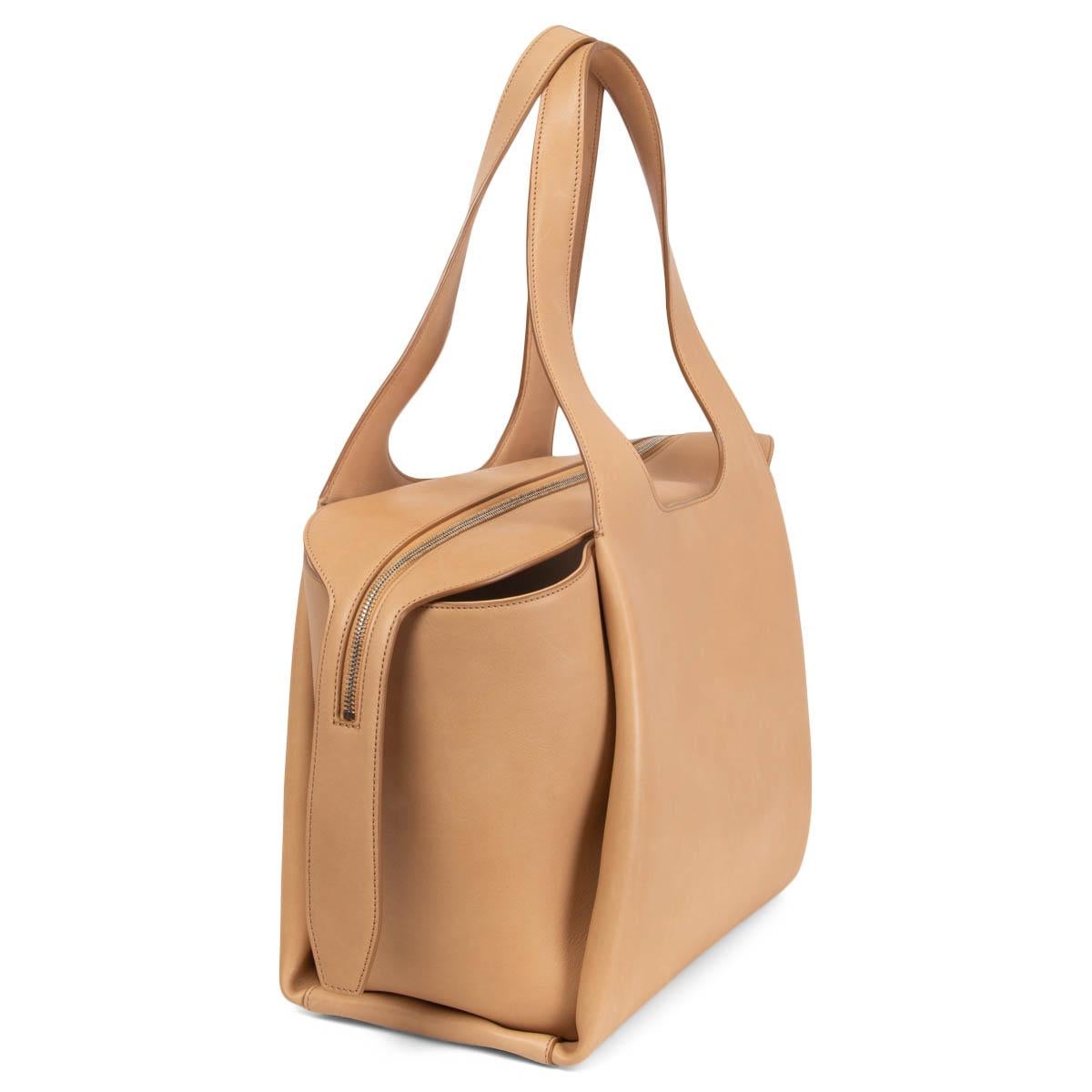 100% authentic The Row Large TR1 shoulder bag in Light Cuir (sand) smooth calfskin. Opens with a zipper on top and is lined in off-white canvas with one zipper pocket against the back. Has been carried once or twice and shows some soft scratches to
