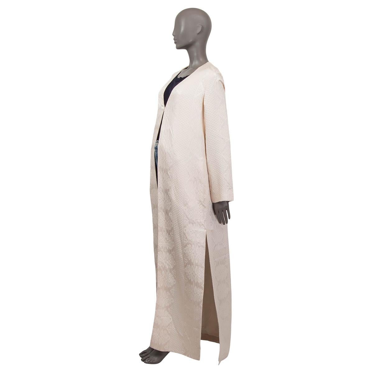 100% authentic The Row 'Muan' coat in pearl Matelassé wool (56%), meryl (36%) and silk (8% - please note the content tag is missing). Features ornamental pattern and two side-slits. Has long flared sleeves and two slit pockets on the side. Opens