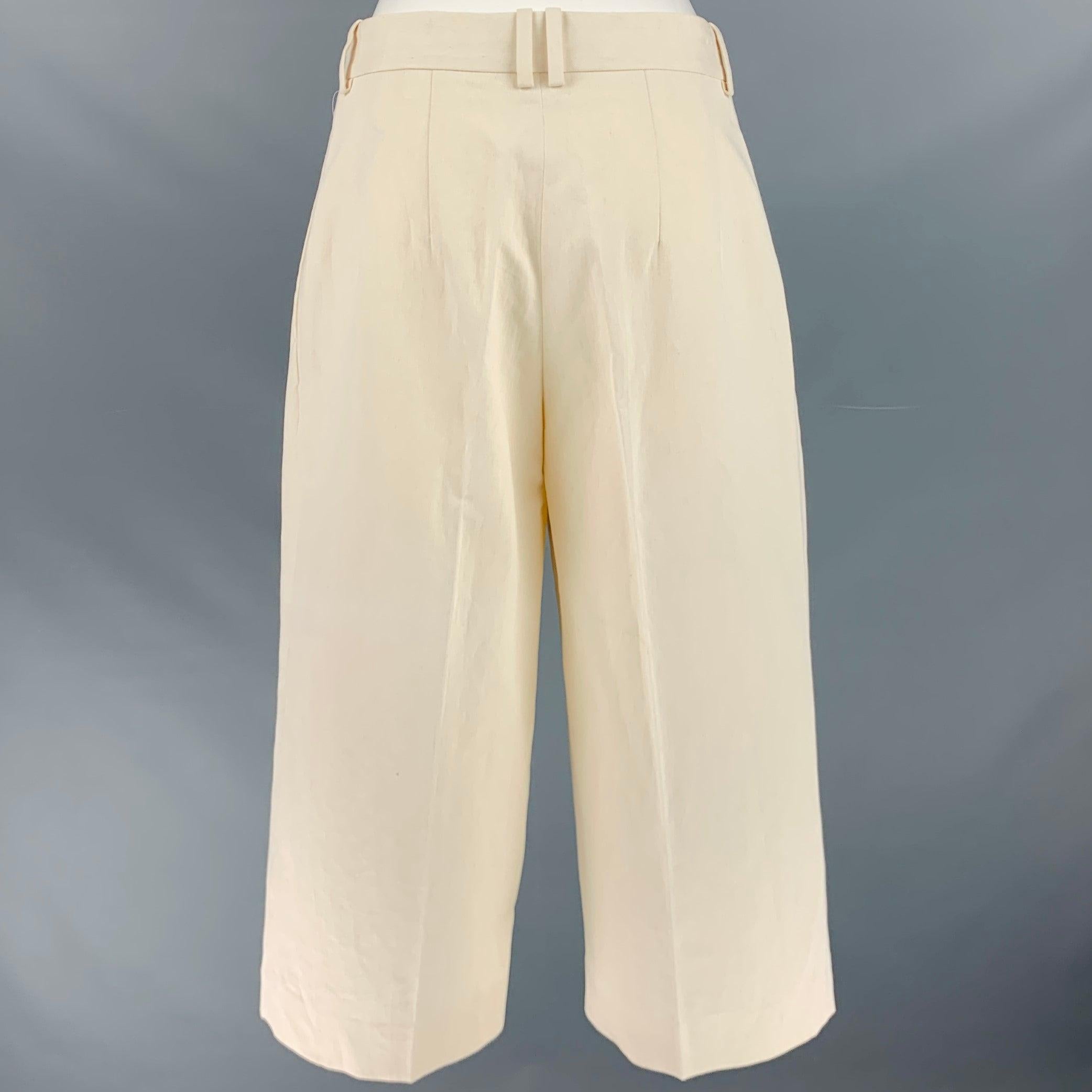 THE ROW dress pants
in a cream cotton linen blend fabric featuring a pleated cropped style, wide leg, and zip fly closure. Made in Italy.Excellent Pre-Owned Condition. 

Marked:   0 

Measurements: 
  Waist: 29 inches Rise: 10 inches Inseam: 19.5