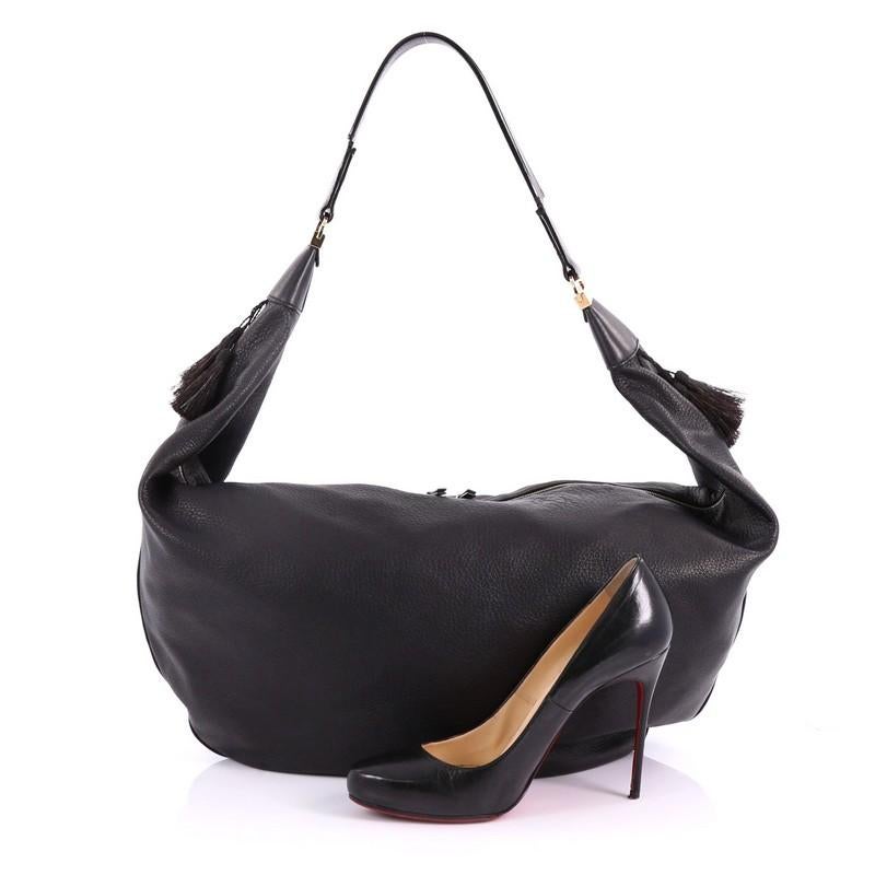 This The Row Sling Hobo Leather 15, crafted from black leather, features wide flat leather strap and gold-tone hardware. Its zip closure opens to a navy fabric interior with slip pocket. **Note: Shoe photographed is used as a sizing reference, and