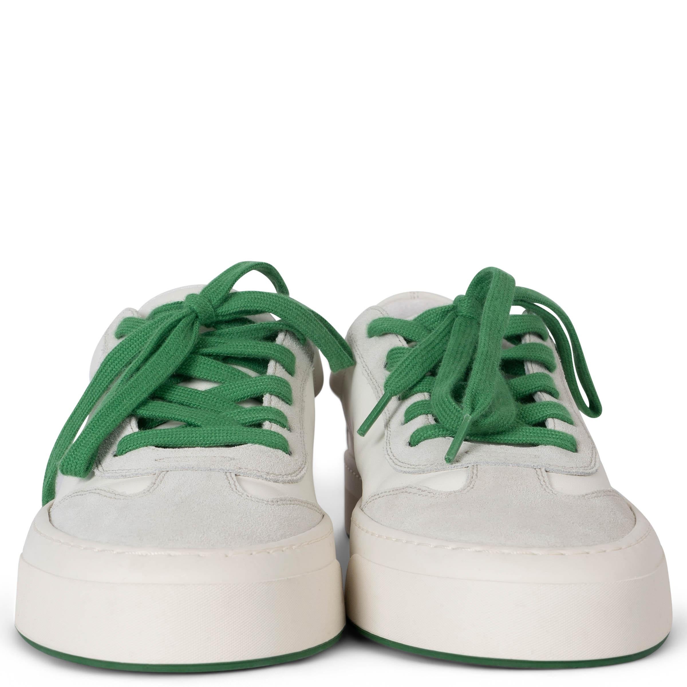 These 100% authentic The Row Marley low-top sneakers are crafted from a combination of white leather and pale grey suede, offering a sleek and modern design. They feature round toes, green laces for a subtle pop of color, and durable rubber soles,