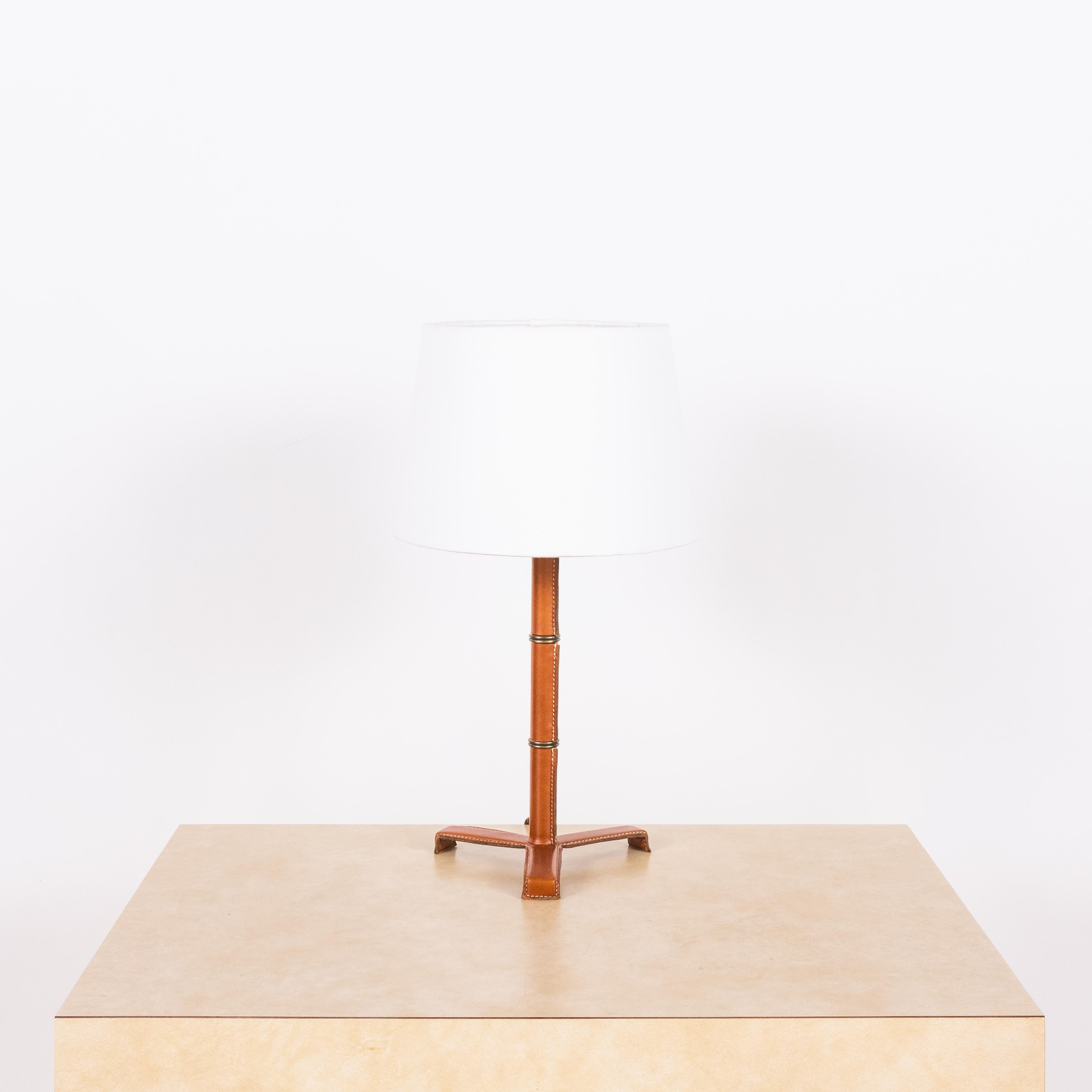 Introducing the 'Sellier' French modernist-style stitched tan leather table lamp by Design Frères.

Crafted from premium black leather, the stitched detailing adds a touch of sophistication, while the parchment paper shade emits a warm and inviting