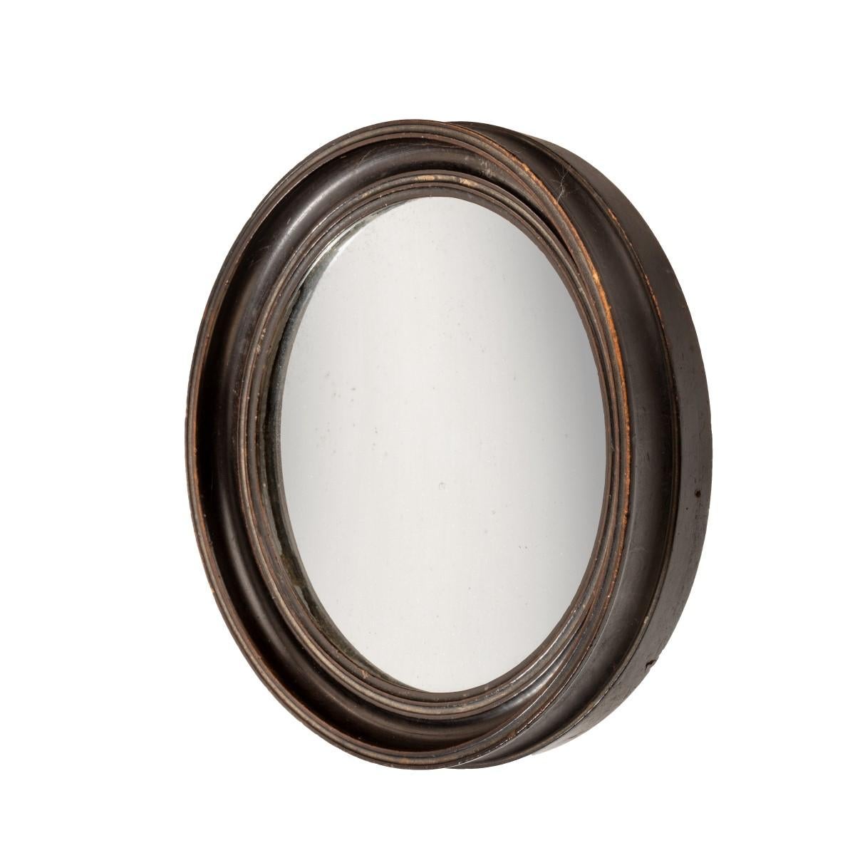 This concave, circular shaving mirror is set in a moulded ebonized wood frame. The reverse has a printed trade label stating ‘J Abraham Optician & Mathematical Instrument Maker to his R. H. Duke of Gloucester & His Grace the Duke of Wellington. 7