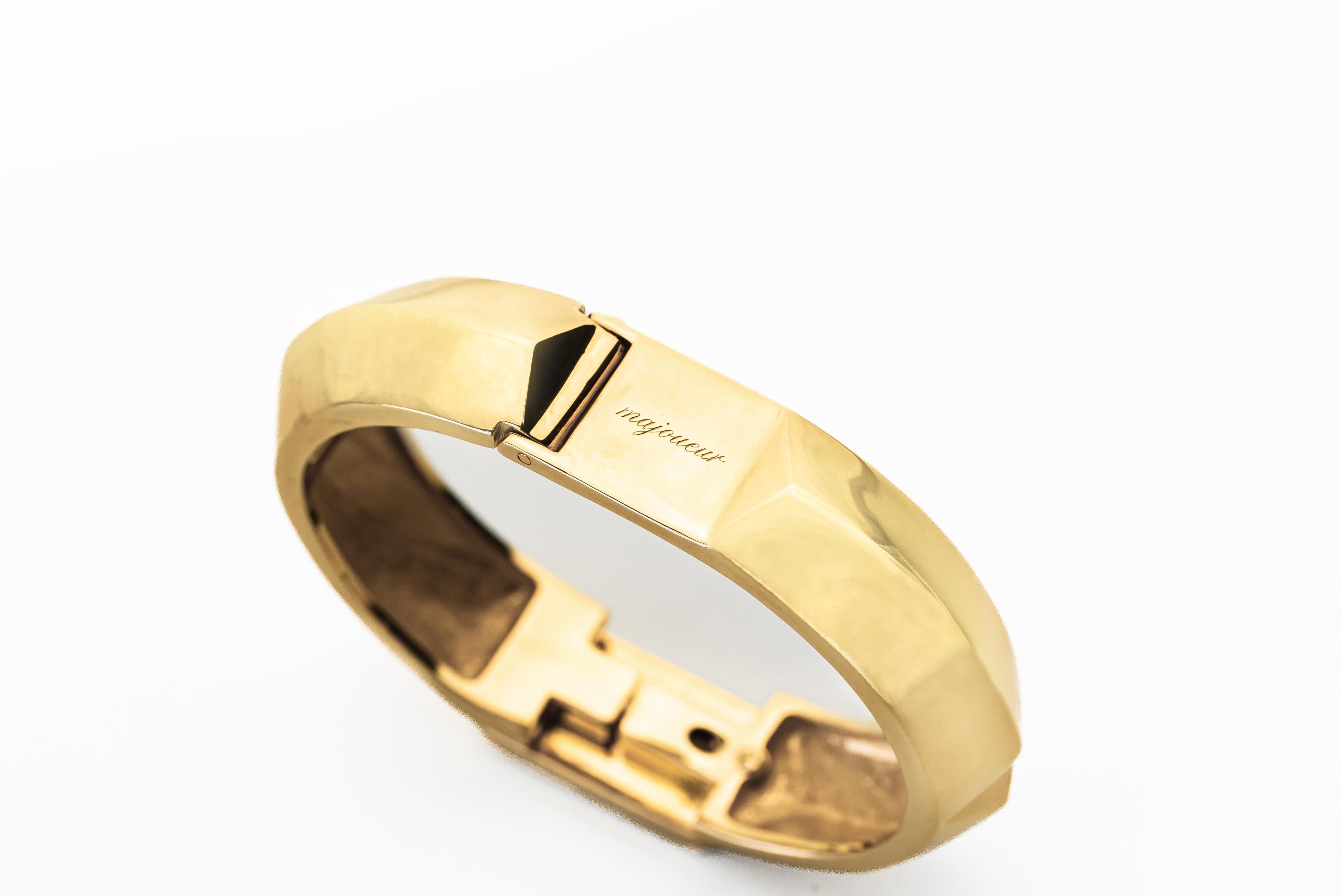 Embrace the liberating opportunity to authentically express your true self. Within this exquisite bangle, the opulent radiance of pure gold harmoniously juxtaposes with the ethereal, transparent azure hues, expertly crafted through the culmination