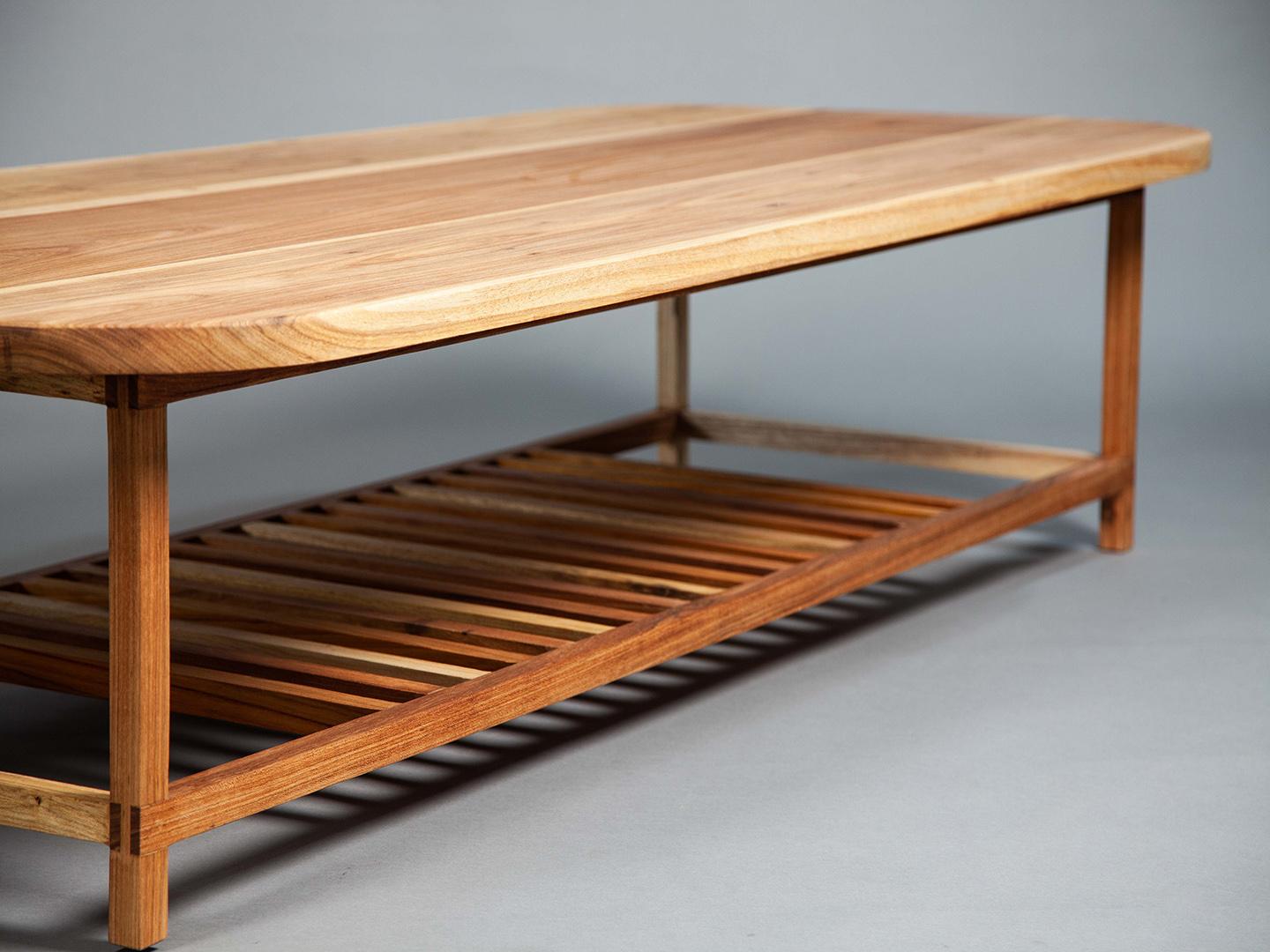 Der Slatted Coffee Table verbindet nahtlos die geraden Linien seines Gestells mit dem abgerundeten Design seiner Tischplatte und schafft so ein harmonisches und elegantes Möbelstück. Unter der Tischplatte befindet sich ein Lattenrost, der dem