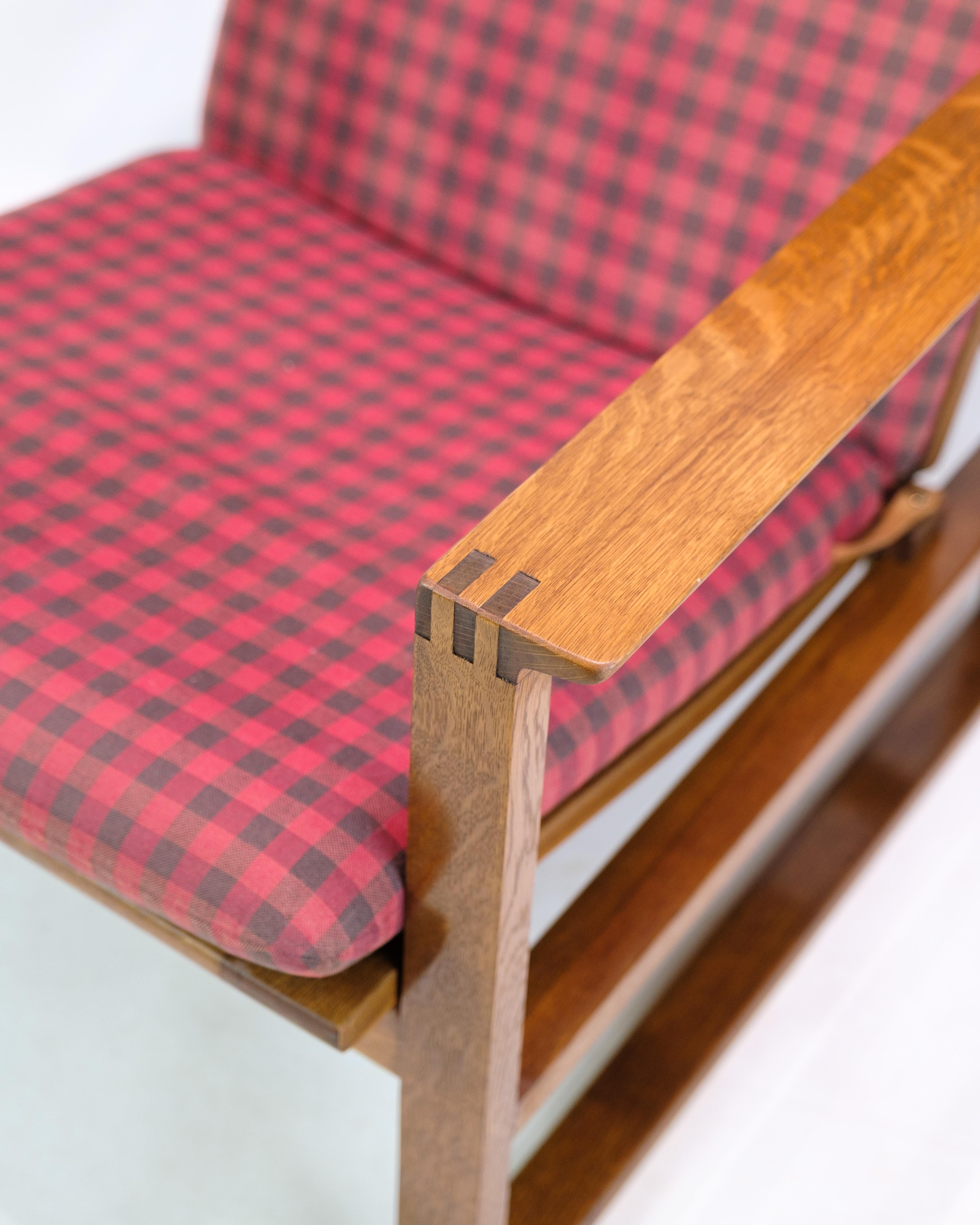 Sedia a slitta originale, modello BM2254, disegnata da Børge Mogensen nel 1958 e prodotta da Fredericia Stolefabrik. La sedia è realizzata in rovere oliato con giunture a tenone e cuscini sciolti in tessuto rosso/scacchiera e cuscino per il