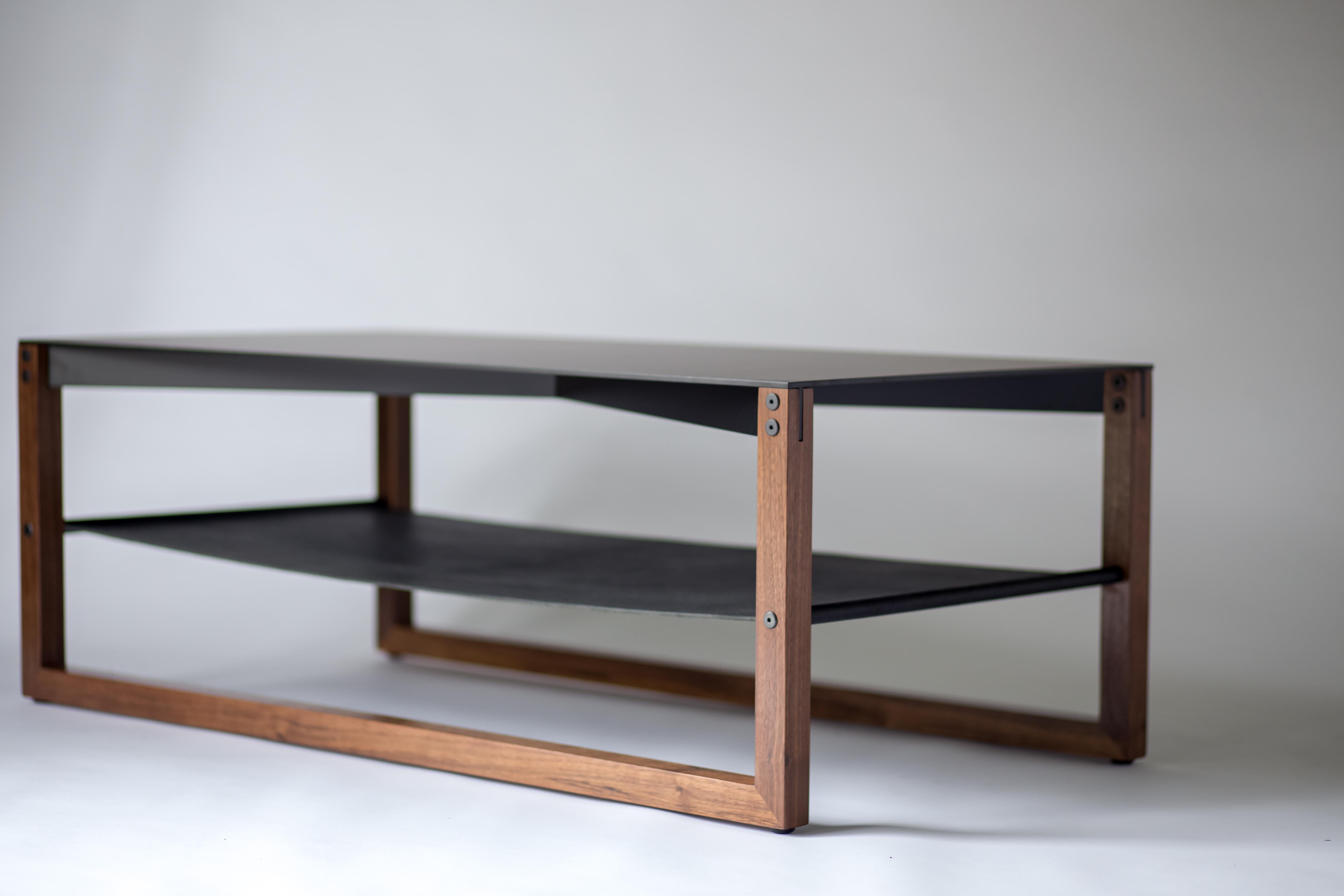 The Sling - modern aluminum, leather, and walnut coffee table

Minimal and elegant form paired with a balanced and thoughtful design. The Sling coffee table features powder-coated aluminum, blackened hand-stitched leather, and hand finished