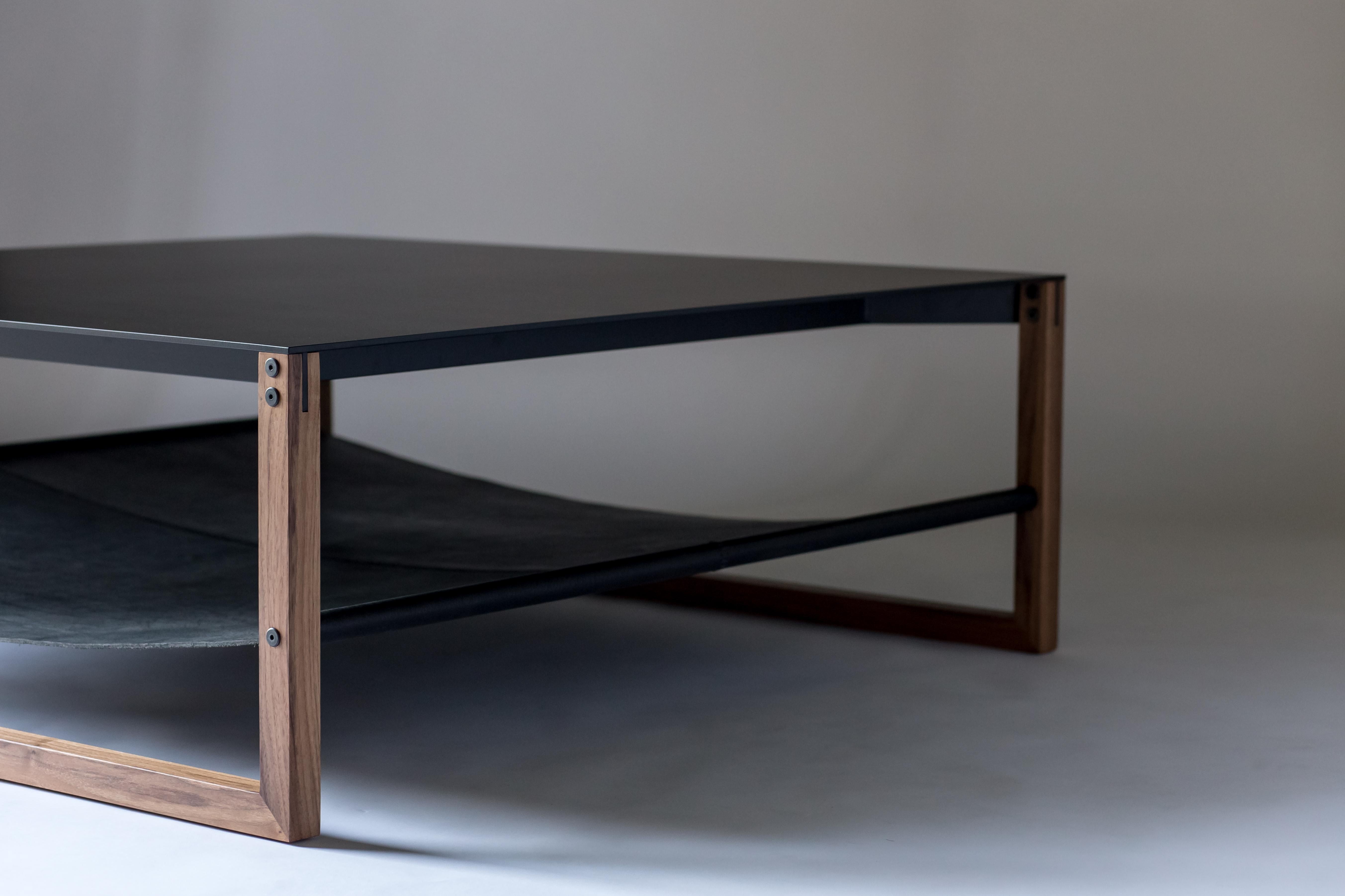 The Sling, modern aluminum, leather and walnut square coffee table.

Minimal and elegant form paired with a balanced and thoughtful design. The Sling coffee table features powder-coated aluminum, blackened hand-stitched leather, and hand finished
