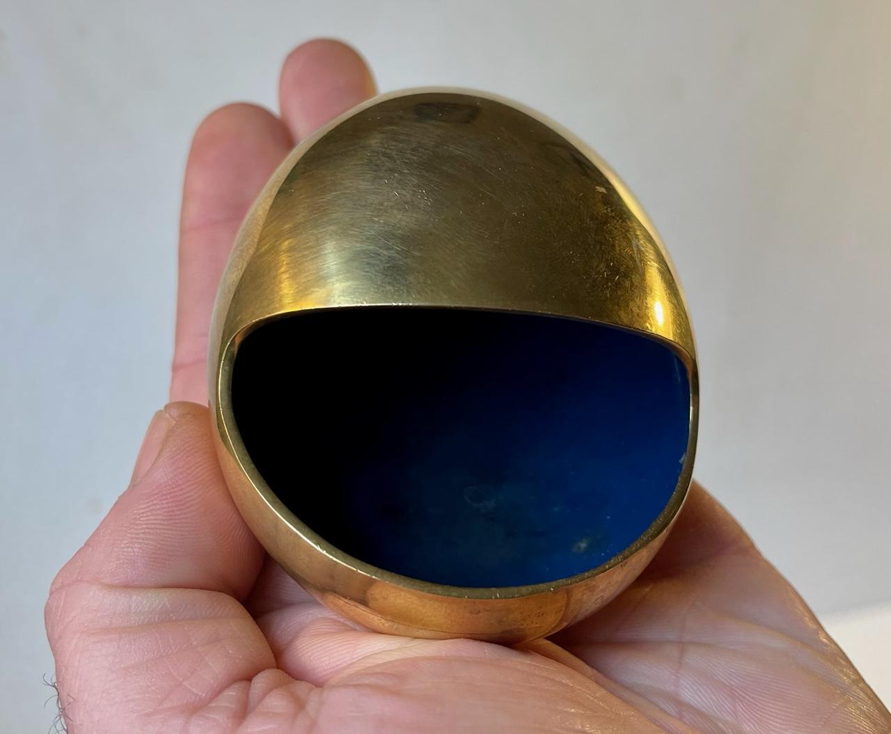 Iconic egg shaped brass ashtray with blue interior enamel. It is called the smile and was designed by Hans Bunde and manufactured by Carl Cohr in Fredericia Denmark during the 1950s. Stamped Cohr, Denmark - to the base. It remains in beautiful