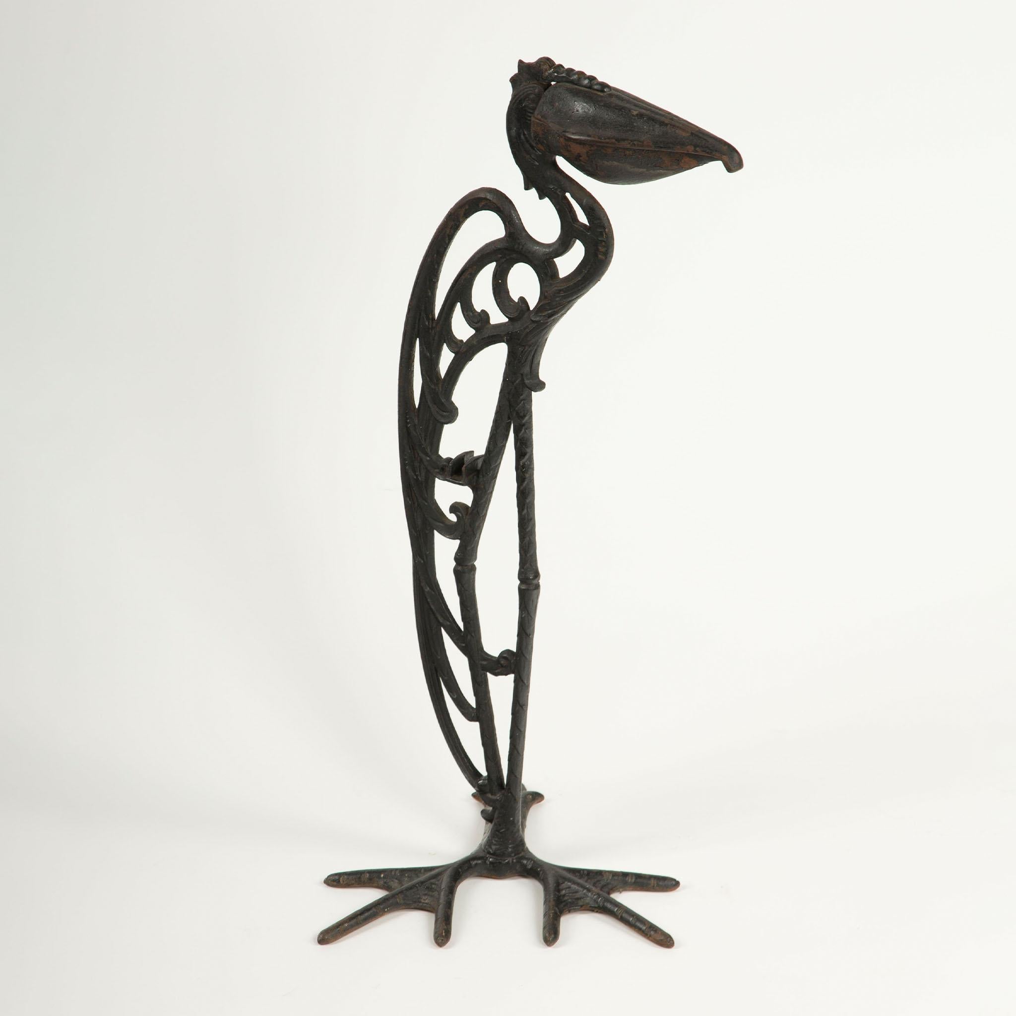 Cendrier cigogne en fonte,  Milieu du 20e siècle

Remarquable cendrier sculptural en forme d'Eleg, finement moulé en fer, avec un élégant corps ajouré et un grand bec articulé qui sert de réceptacle à cendres fonctionnel. Reposant sur de larges