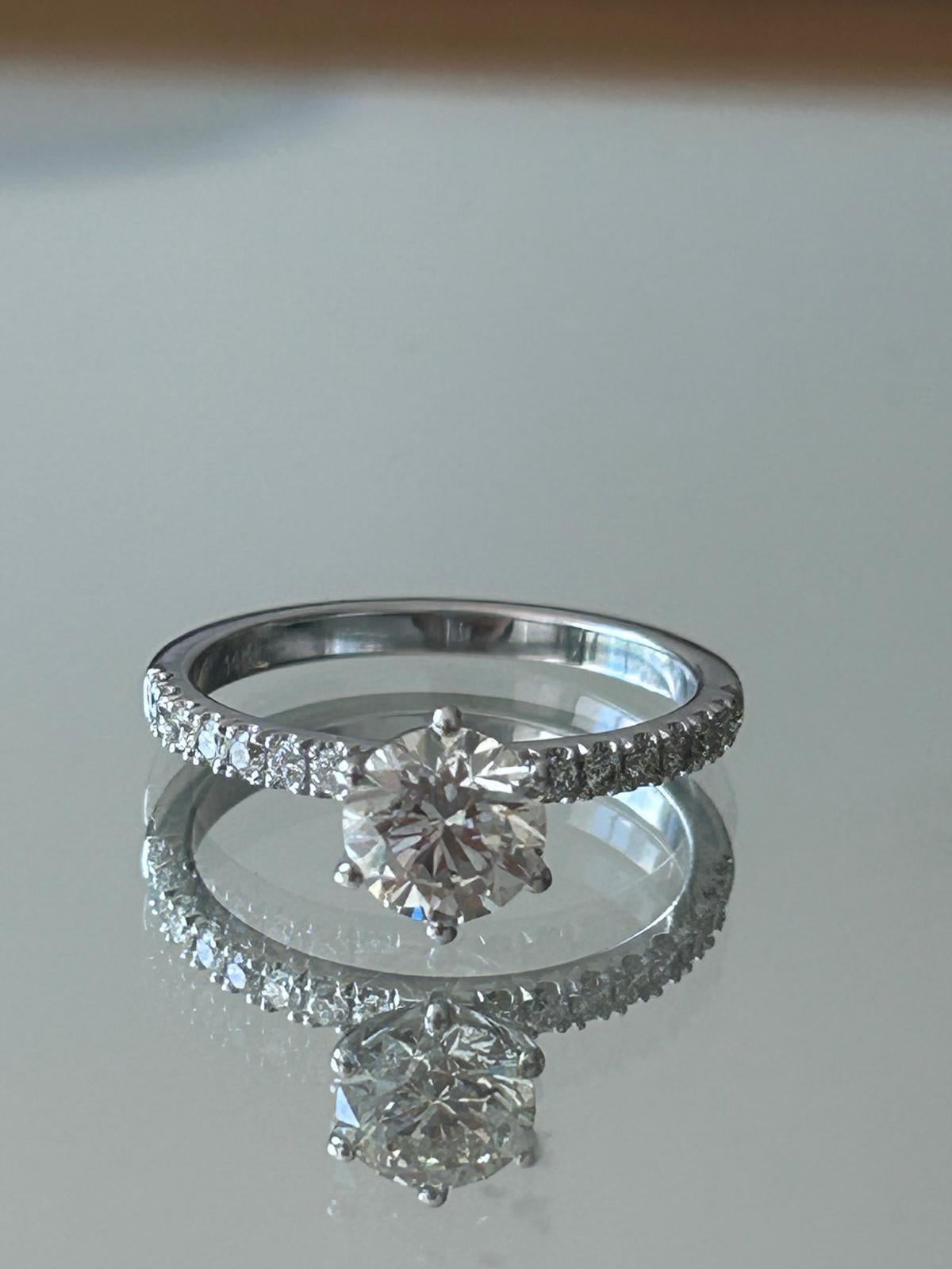 Zeitlose Eleganz in jedem Detail ✨
Verlieben Sie sich in diesen exquisiten Diamantring aus glattem 17 Karat Weißgold (2,9 g).
💎 Mit einem schillernden runden Diamanten von 1,03 Karat in der Mitte
💫 Akzentuiert mit 16 funkelnden Steinen von