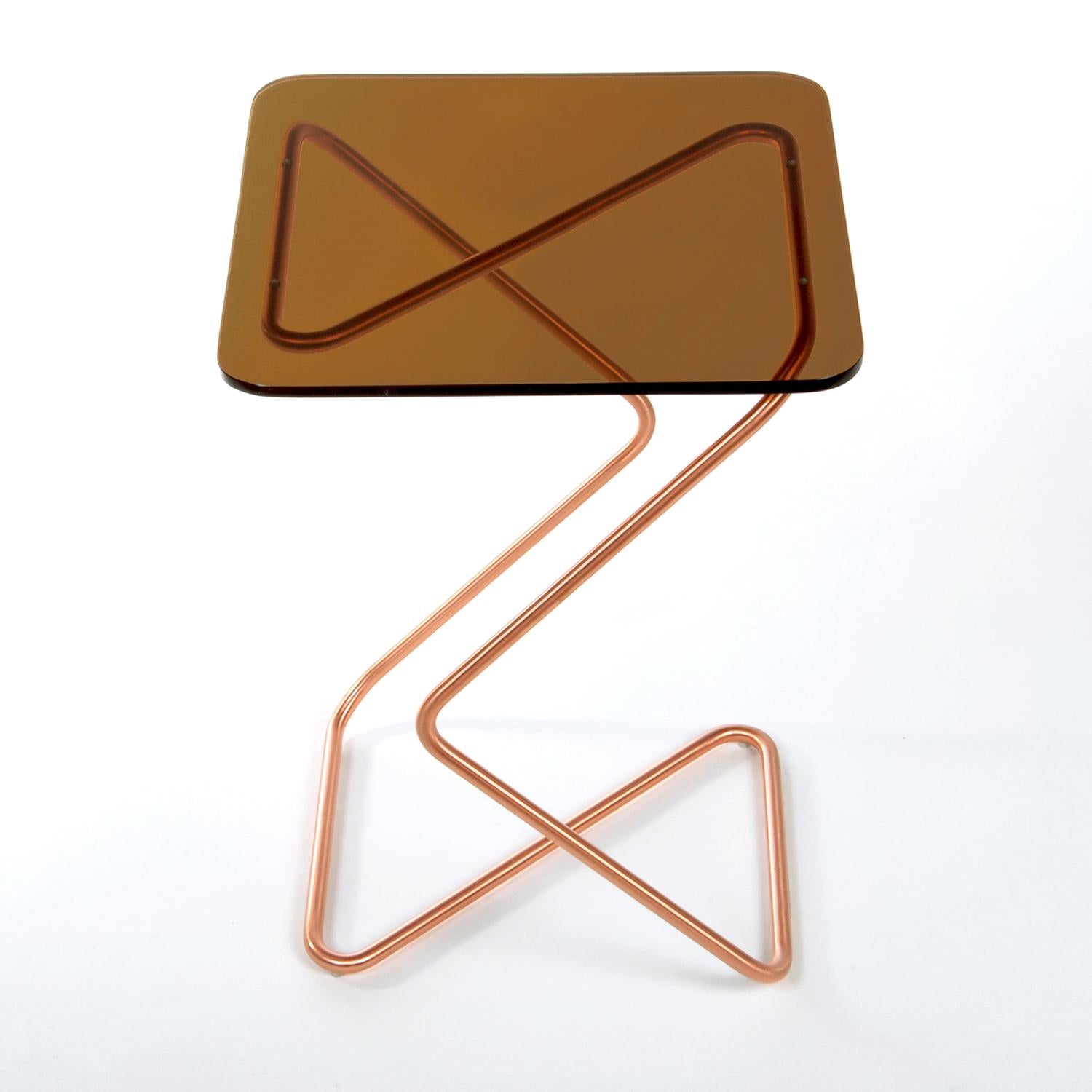 The square side table by Rita Kettaneh 
Dimensions: The base: brushed stainless steel plated with copper 
 optionally plated with copper or brass
 The top: acrylic
Materials: H 46 x W 33 x D 33 cm
Weight: 3.75 Kg

Colors and Finishes: