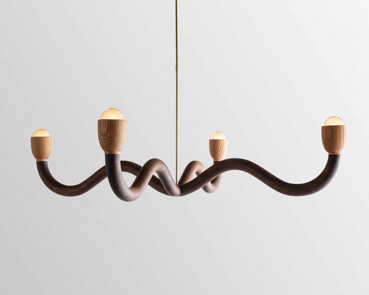 The Squiggle chandelier was created though an exploration of shaping solid walnut slab lumber. Designed to bring a smile to any space, each light is thoughtfully selected to highlight the grain pattern and characteristics of American black walnut.
