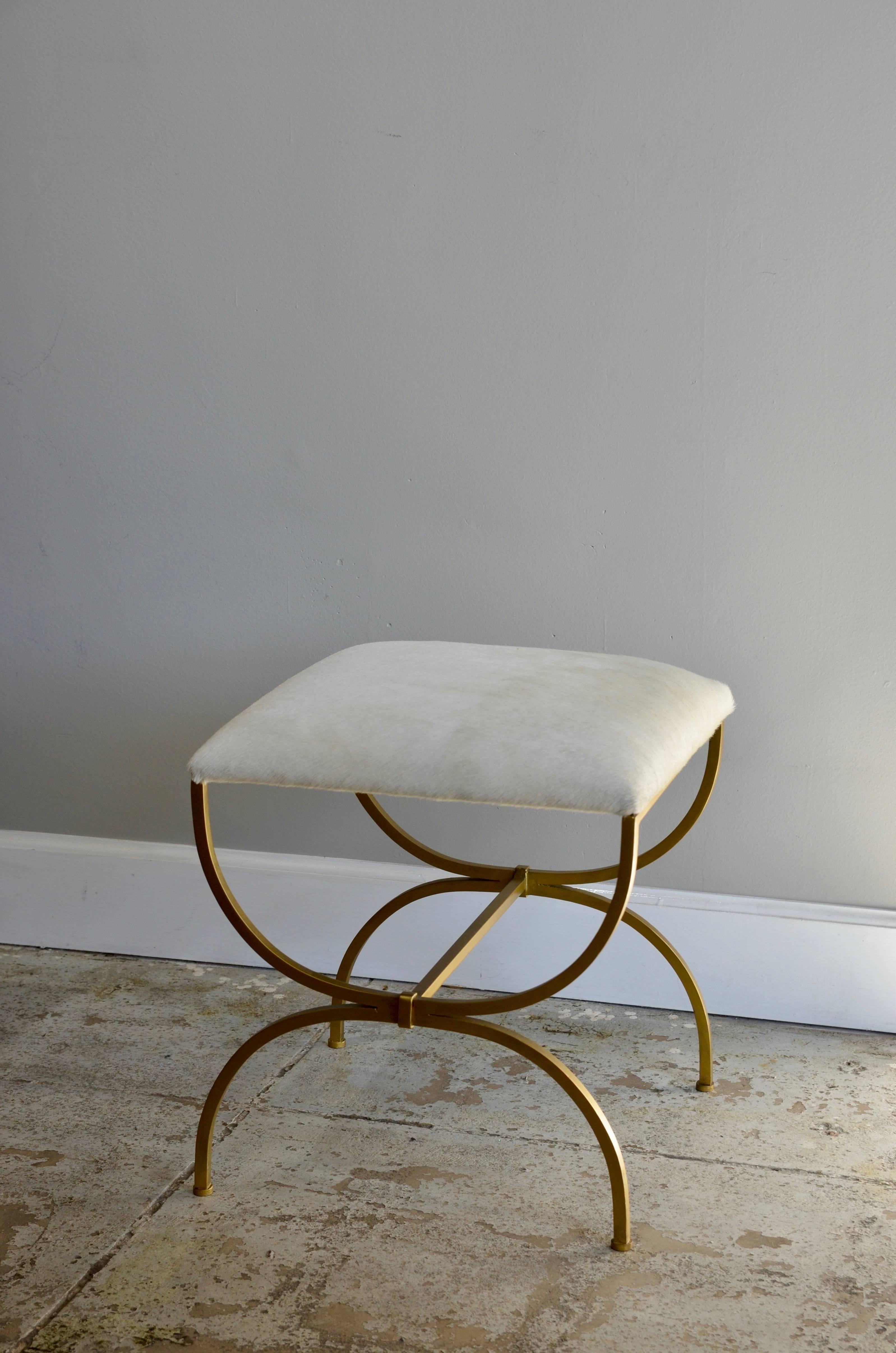The 'Strapontin' gilt metal and white hide stool by Design Frères.