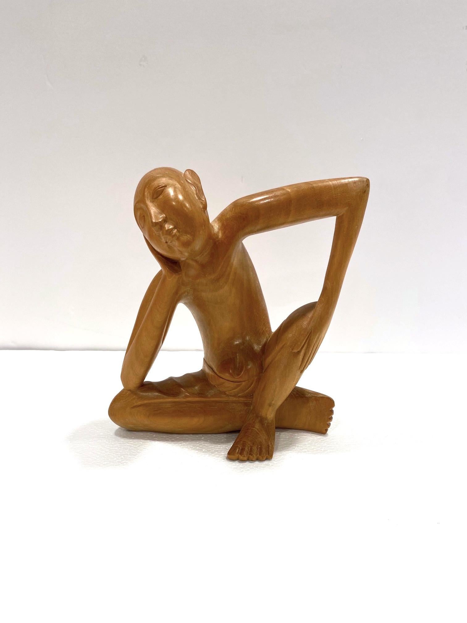 1970's Balinese figural sculpture in solid reclaimed suar wood. Artisan made with exquisite hand carved details. This sculpture features a sitting man in a pensive or contemplative state, perhaps a daydreamer. The striking posture creates a linear