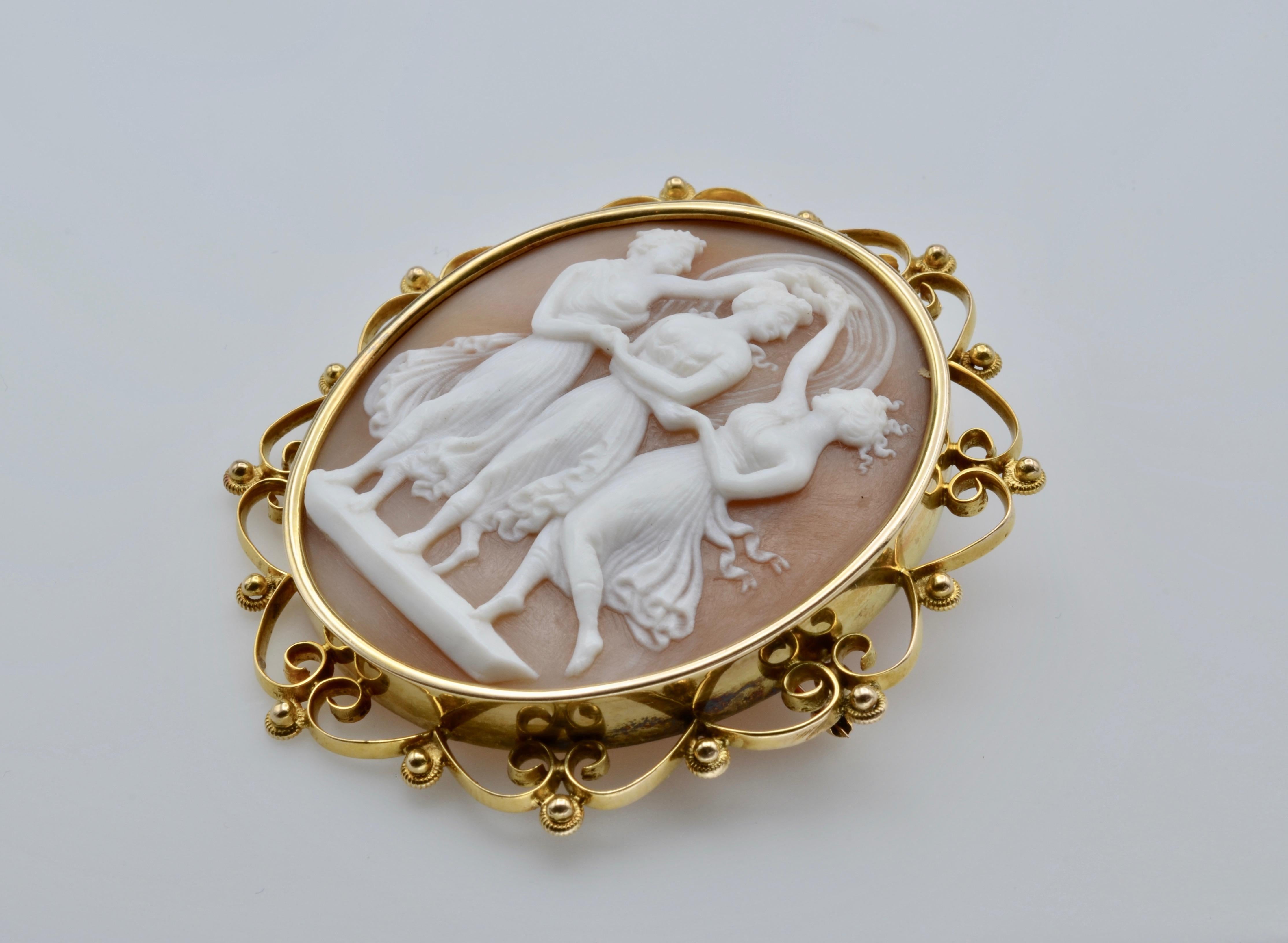 This elegant cameo brooch from the Late Victorian era is an excellent example of shell carving depicting the three Graces. The 14k gold setting is a wonderful filigree design that adds to the fluidity of the dancers in movement. The pin has a secure