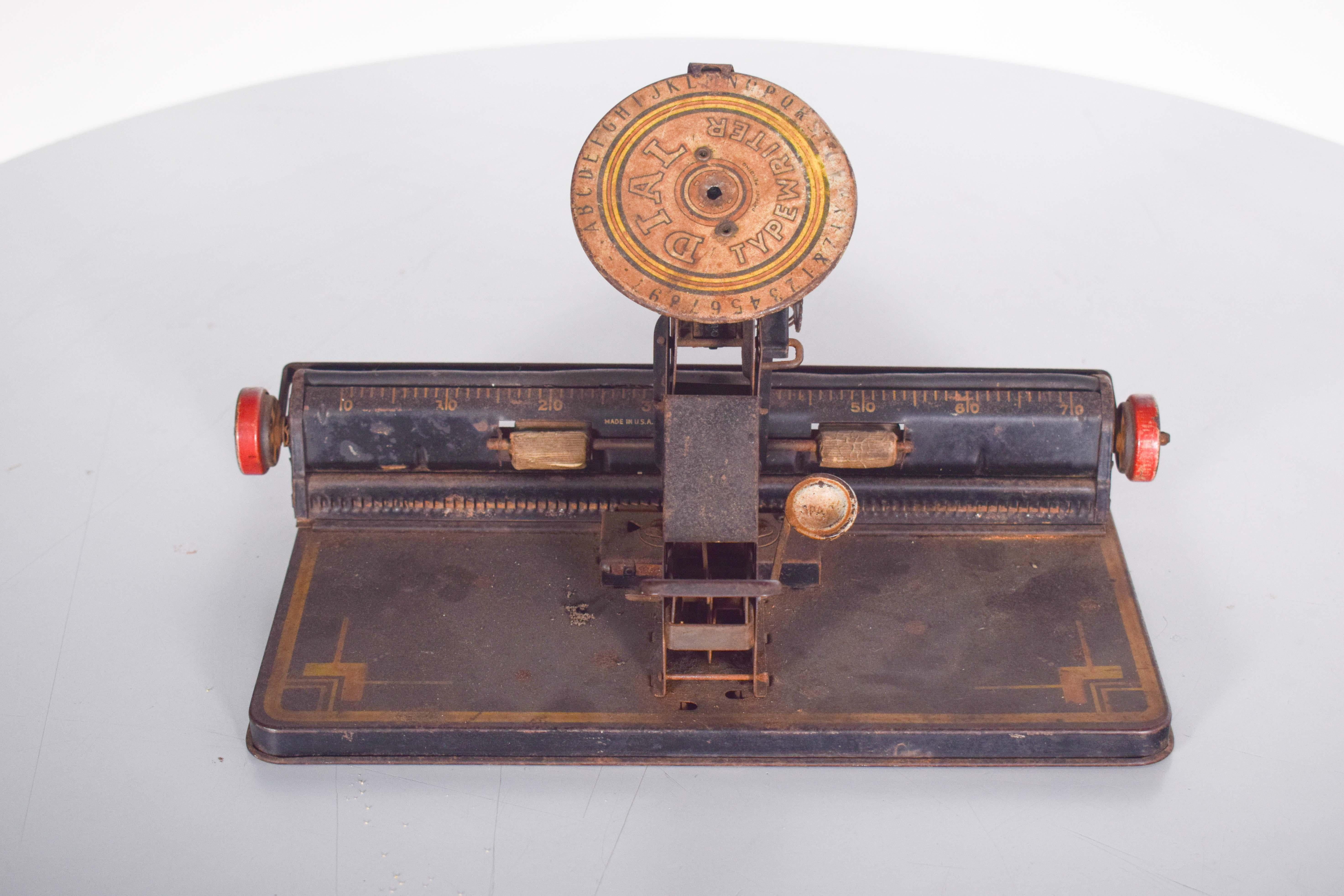 Die Spielzeugschreibmaschine DIAL Typewriter ist ein seltenes und eigenartiges Modell, das Anfang des 20. XX, um 1920 von Louis Marx and Company.
Verwenden Sie anstelle einer herkömmlichen Tastatur ein kreisförmiges Gerät, bei dem Buchstaben, Zahlen