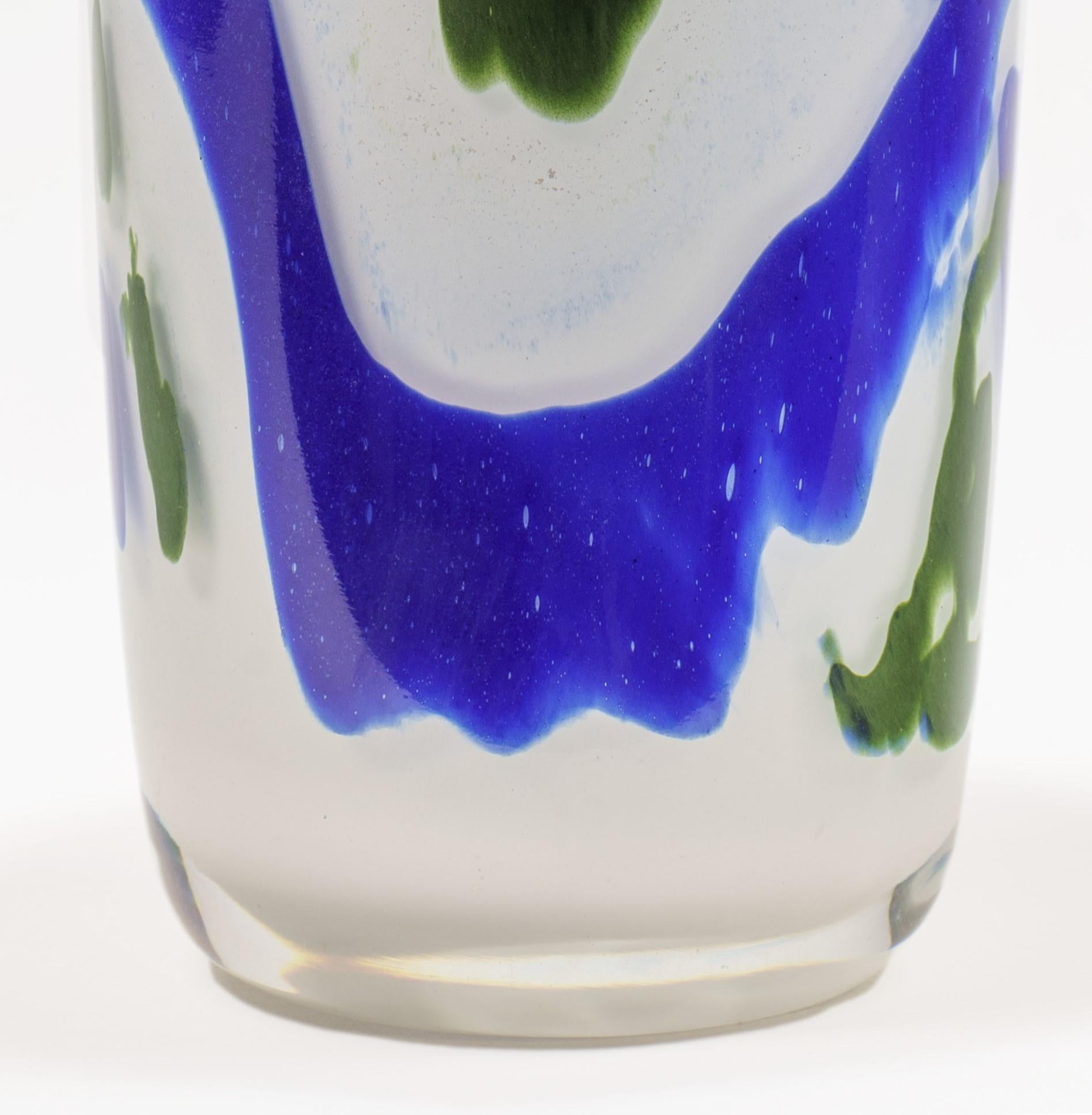 Jeremiah Whiting est un artiste verrier hautement qualifié qui a créé une magnifique pièce en verre soufflé en utilisant des tourbillons bleus et verts sur un fond blanc. Cette pièce est un exemple stupéfiant de l'art et du savoir-faire qui