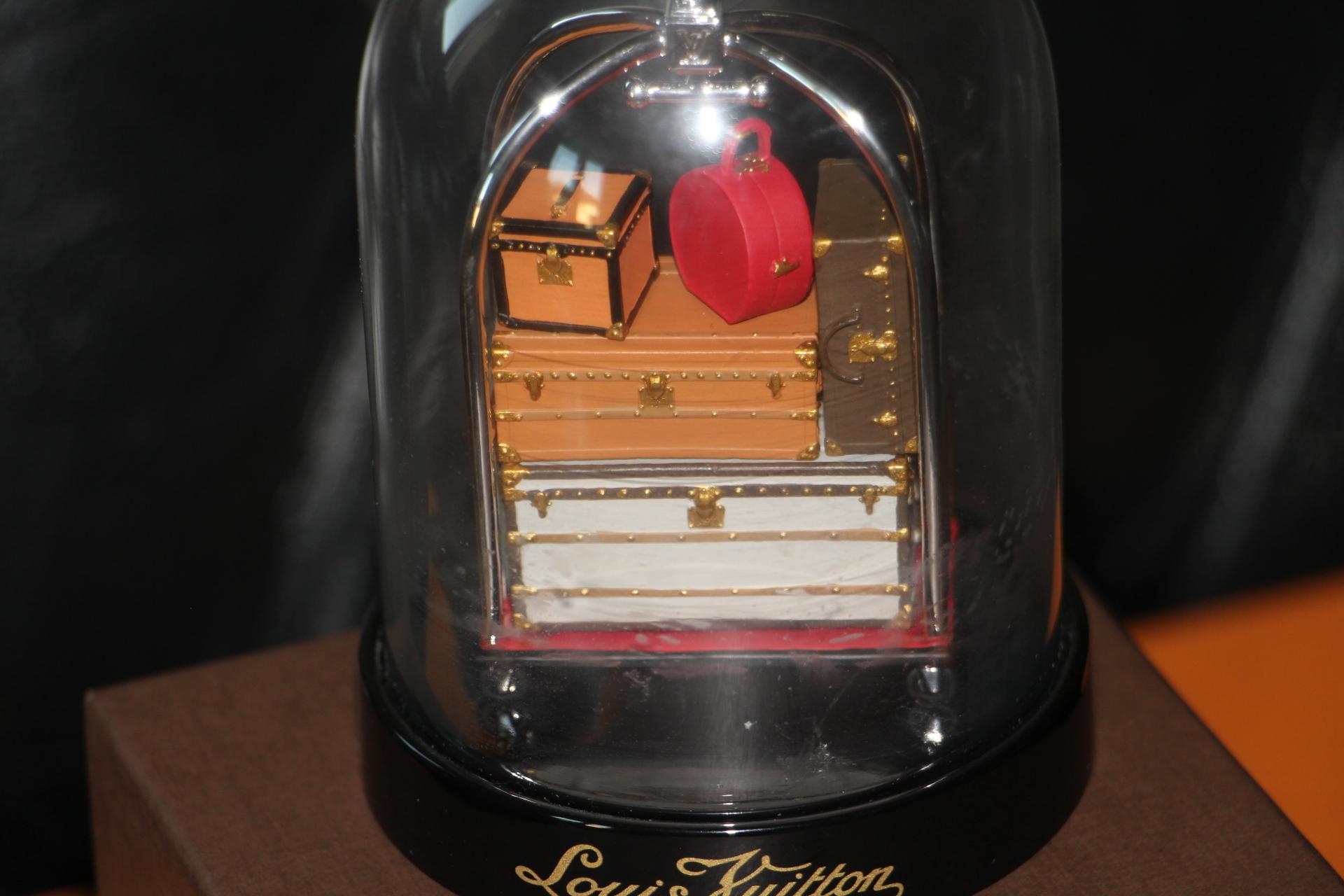 This Louis Vuitton VIP Trunk Bag Trolley Snow Globe was commissioned in 2010, extremely limited, a collector's item..
It features a porter trolley with various Vuitton suitcase, as well as hat trunks and steamer trunks . 
It is a very limited